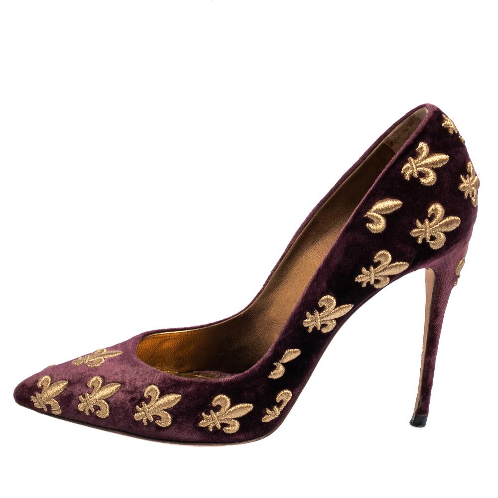 Speak style and glamour with your feet with the Dolce & Gabbana pumps. The luxurious exterior is covered with gorgeous purple velvet with gold-tone embroidery all over. The pointed toe pumps stand on classic stilettos waiting to be coupled with the