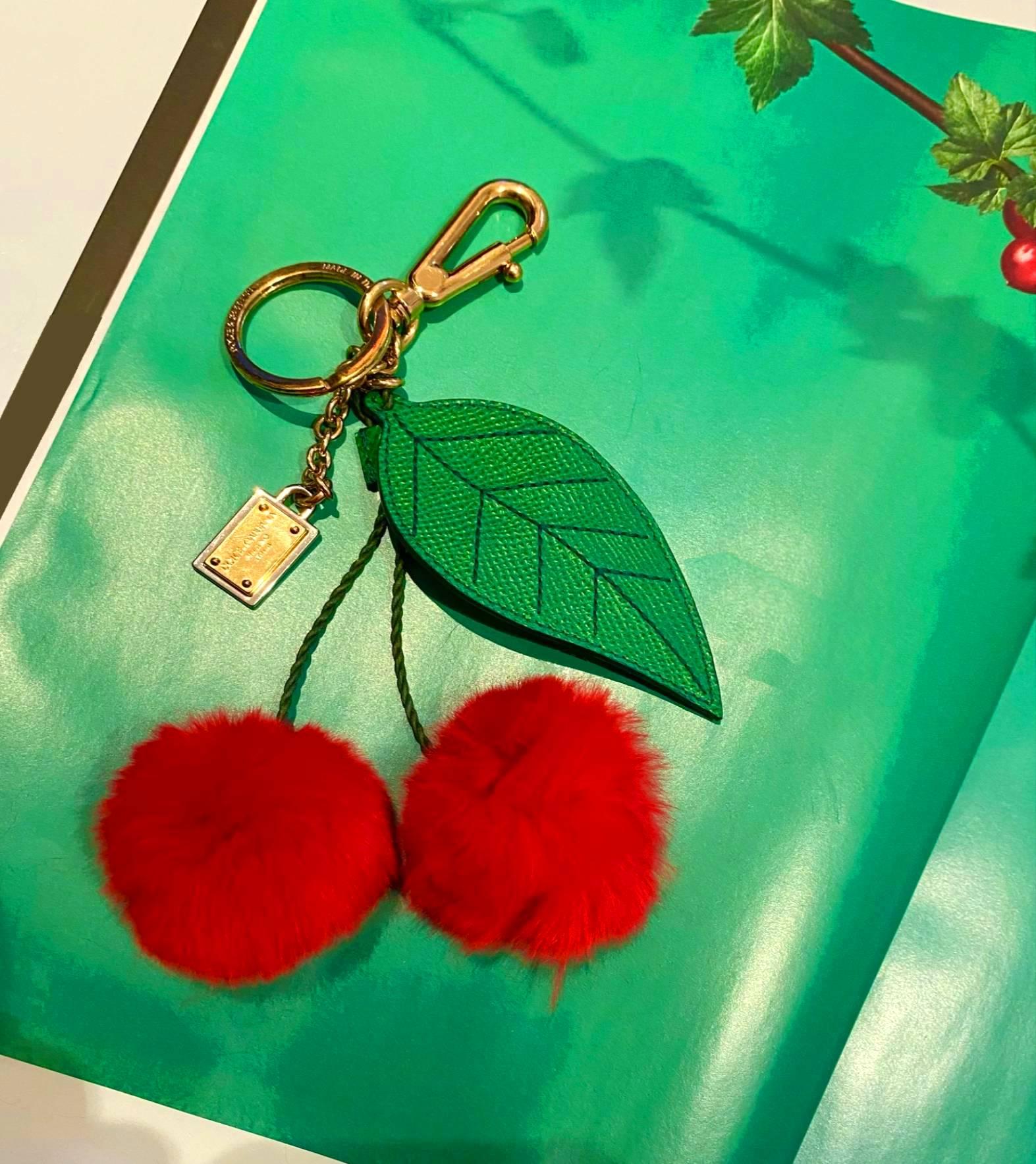 This Dolce & Gabbana charm for example, is so unbelievably pretty. It has two cherry pom poms made of fur and a green leather leaf, all held by gold-tone clasps. You can use it as a bag charm or a key ring.

Hardware: Gold Tone
Exterior Material: