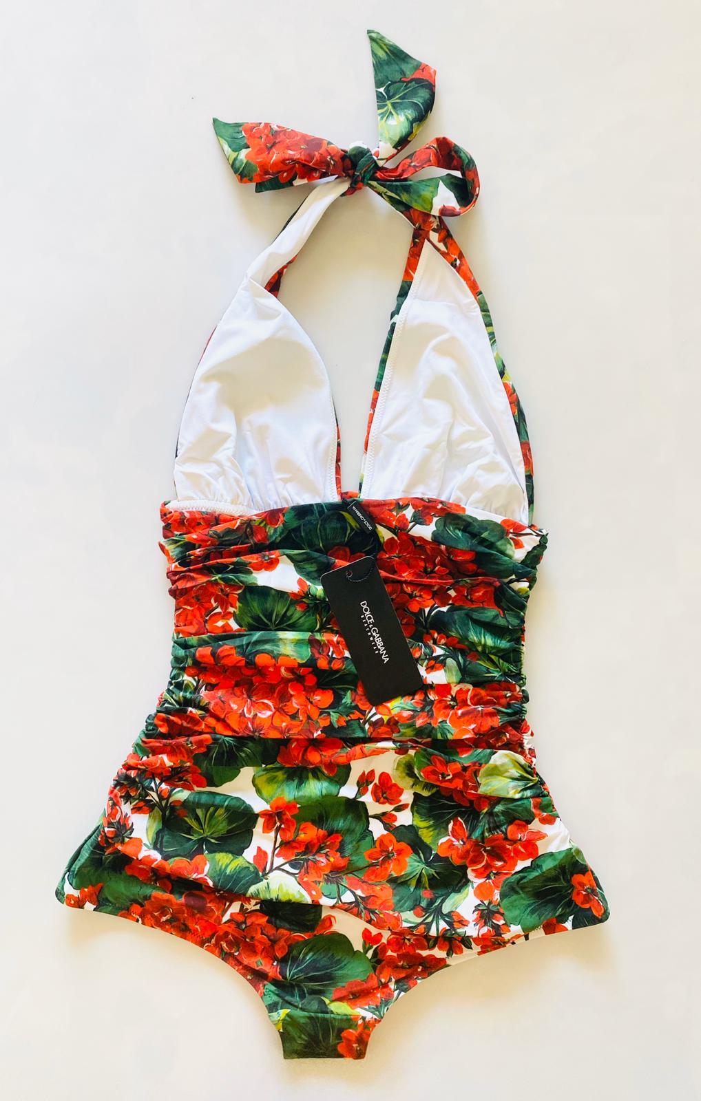 Stunning Dolce & Gabbana one-piece swimsuit which is draped on the sides is made from a precious fabric in the romantic GERANIUM print and has an extraordinarily sophisticated look. 
Perfect for both the poolside and as a top for a cocktail party.