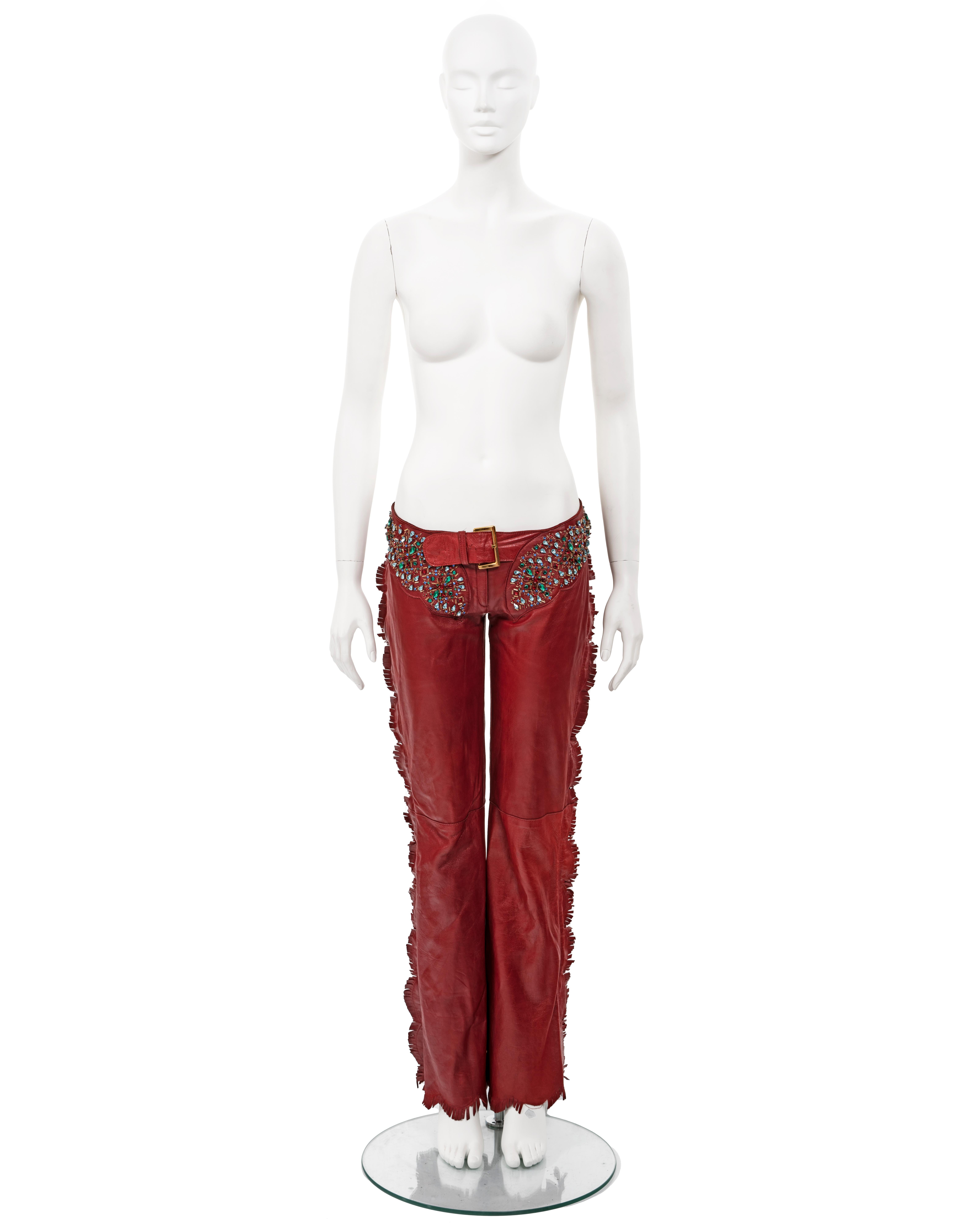 ▪ Dolce & Gabbana red leather pants
▪ Spring-Summer 2001
▪ hand-sewn crystal embellishments around the waistband 
▪ Zippers at the side seam with scalloped fringed trim 
▪ Gold-tone buckles at the centre front and back 
▪ Fully lined 
▪ Waist 33
