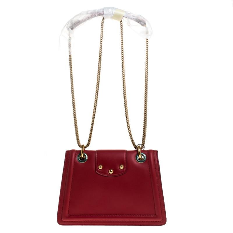 Well-structured and high on style, this DG Amore bag from Dolce & Gabbana deserves to be yours! It has been crafted from red leather and styled with chain-link shoulder straps. It also comes with gold-tone embellished logo detail on the flap that