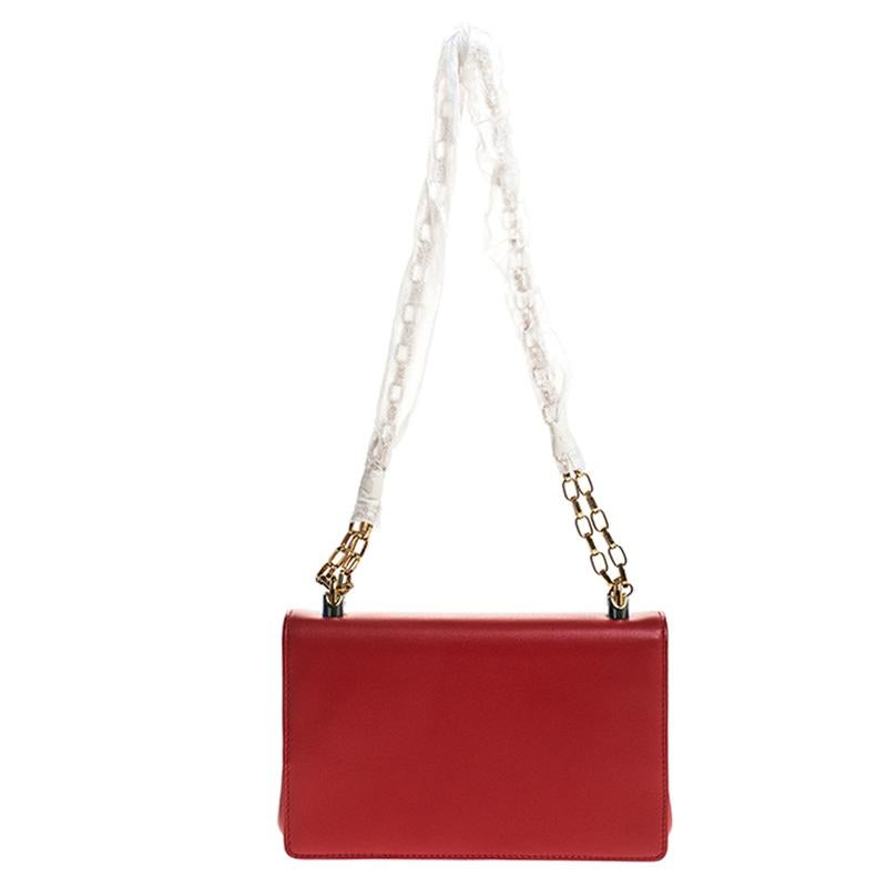 Expertly designed, flaunt this Dolce & Gabbana bag and make heads turn. Crafted from red leather, it features a front flap that leads to a leather-lined interior sized to house your party essentials. The bag is embellished with a jewel-like DG logo