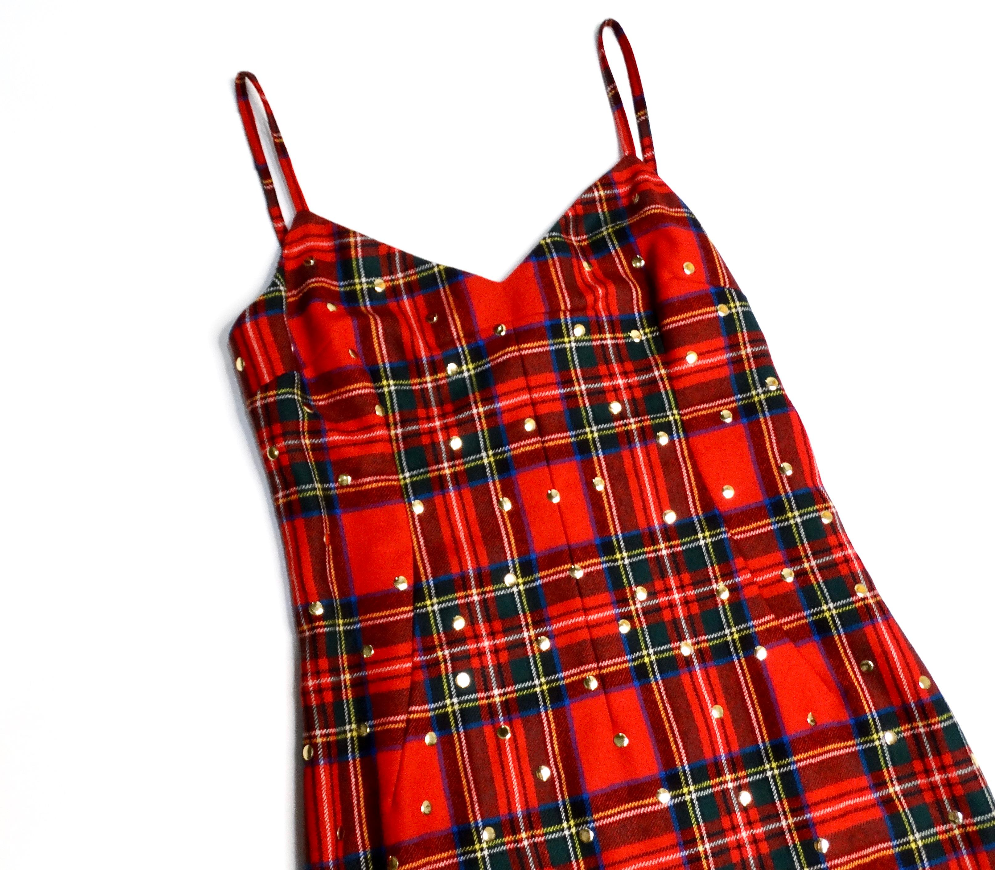 Unleash your inner fashionista with the Dolce & Gabbana Red Plaid Studded Wool Dress, a stunning piece that marries classic with contemporary flair. This form-fitting dress showcases a striking red, green, black, and blue plaid pattern that's both