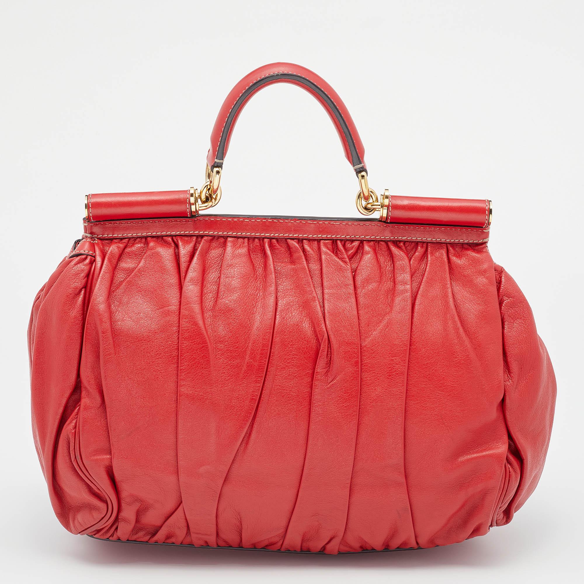 The Miss Sicily bag is one of the most celebrated creations from Dolce & Gabbana. This bag beautifully embodies the spirit of feminity that the Italian luxury brand carries. Crafted from pleated leather, this red top handle bag has a rounded shape