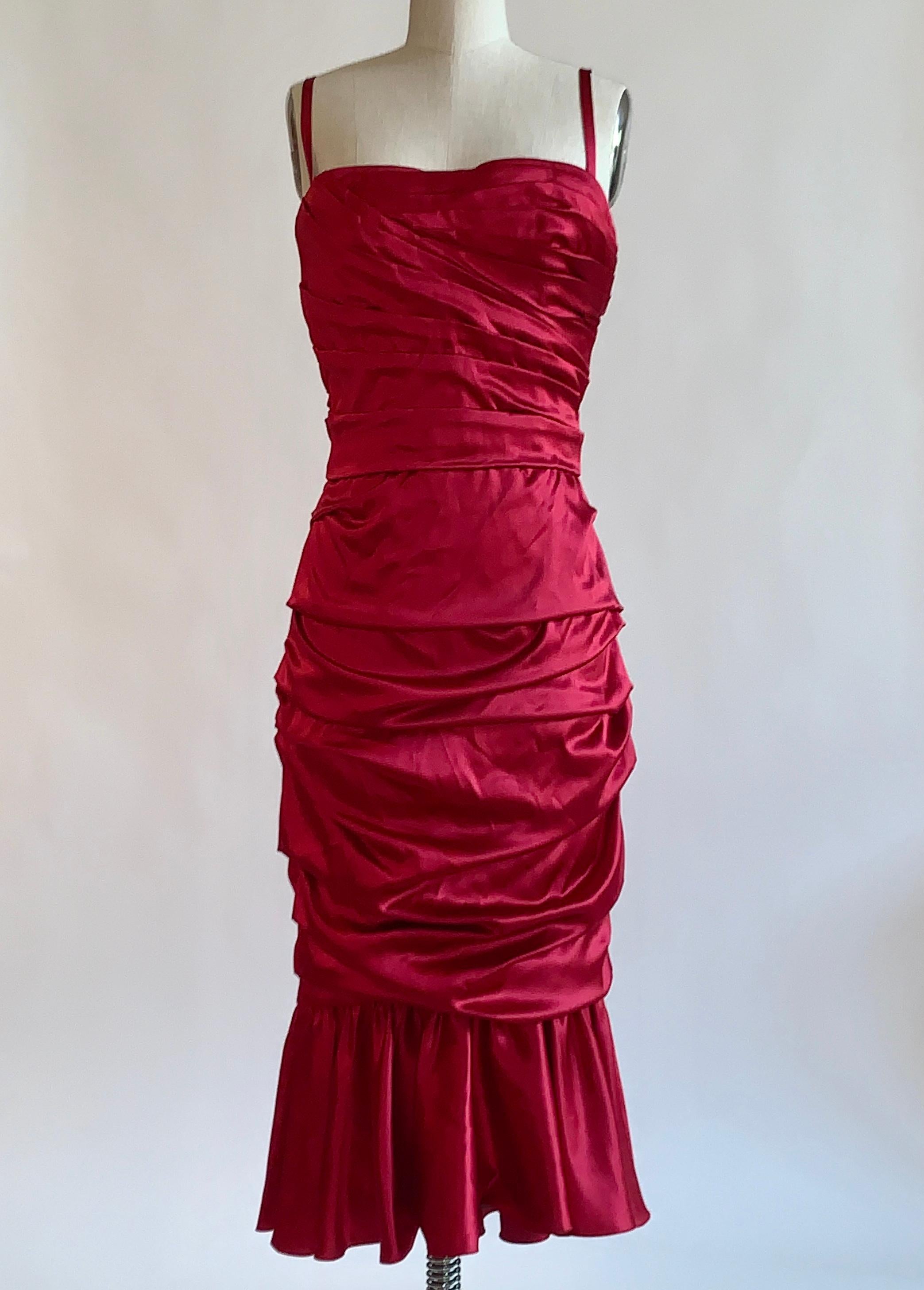 Dolce & Gabbana red ruched silk satin cocktail dress with thin straps and ruffled flounce hem. Built in corset at top. Back zip. 

96% silk, 4% spandex.
Fully lined in 66% silk, 15% cotton, 11% spandex, 8% polyamide.

Made in Italy.

Labelled size