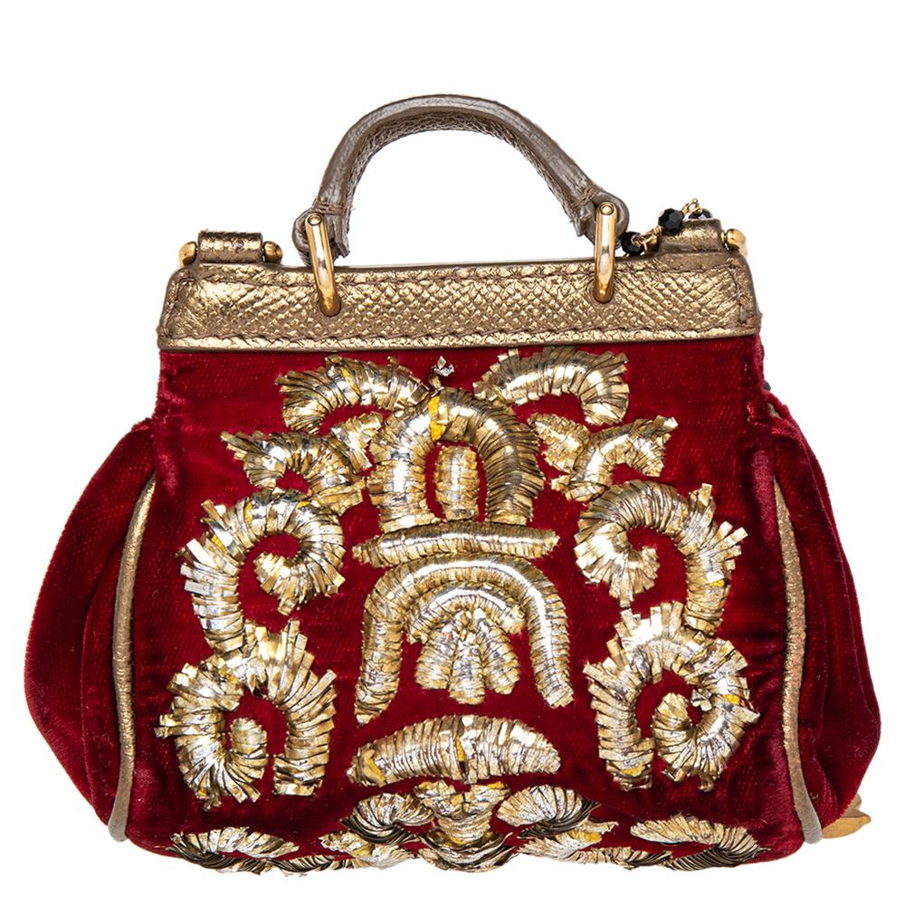 The most beautiful iteration of Dolce & Gabbana's Miss Sicily is this mini version in red velvet. Designed beautifully, it is adorned with contrasting gold-tone embroidery all over the exterior and comes with an embellished chainlink strap. Further,
