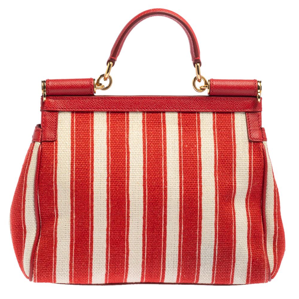 The iconic Miss Sicily bag by Dolce & Gabbana is named after Domenico Dolce's native land and exhibits the aesthetic of Italian glamour. The neat silhouette is made from raffia and leather in a striped pattern and features a front flap accented with