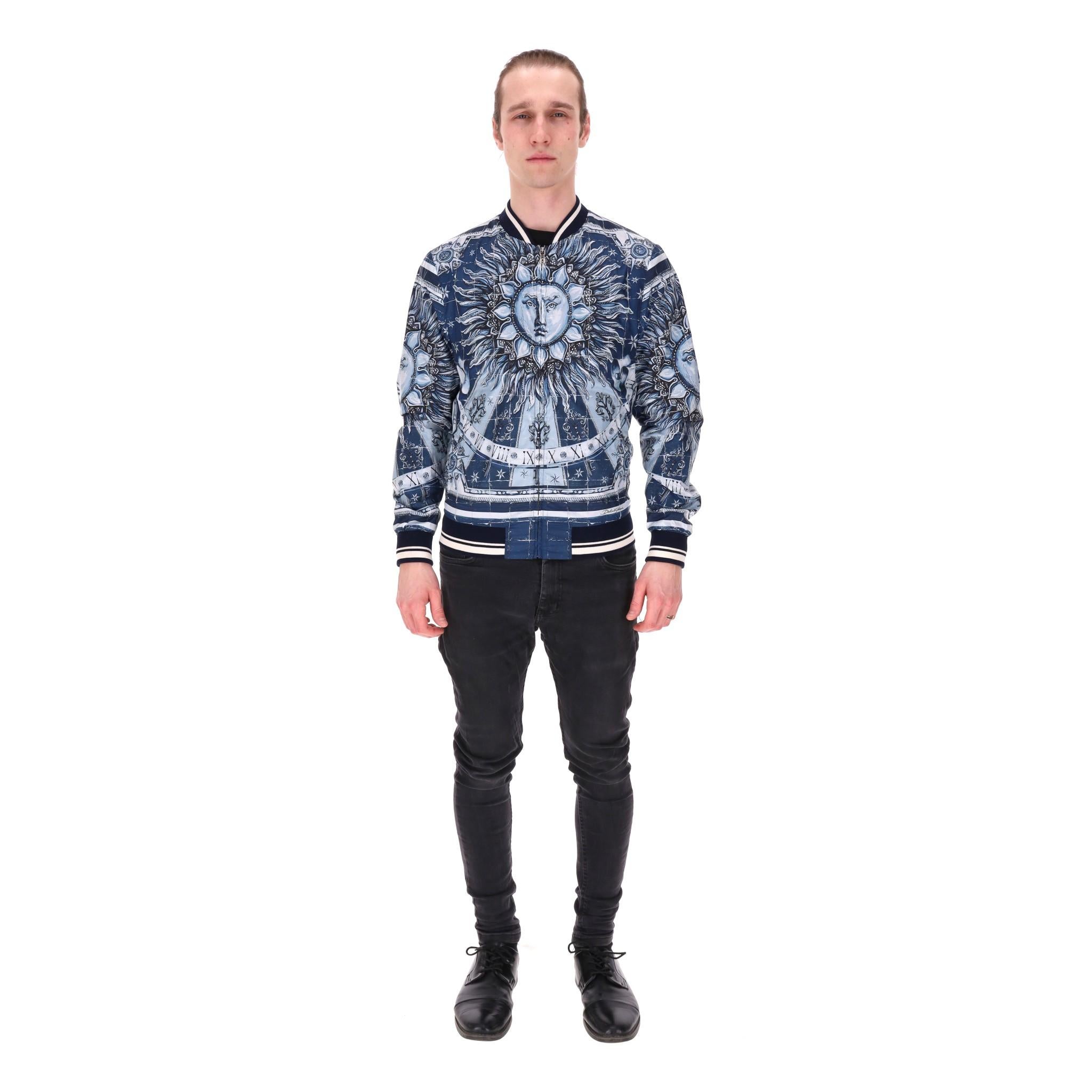 Dolce & Gabbana - Giacca bomber con stampa del sole romano e dello Zodiaco

Bomber blu con motivo Zodiac e Sole romano al centro.

Whiting con polsini, collo e orlo a coste a righe bianche e blu.

Chiusura centrale con zip e tasche laterali a
