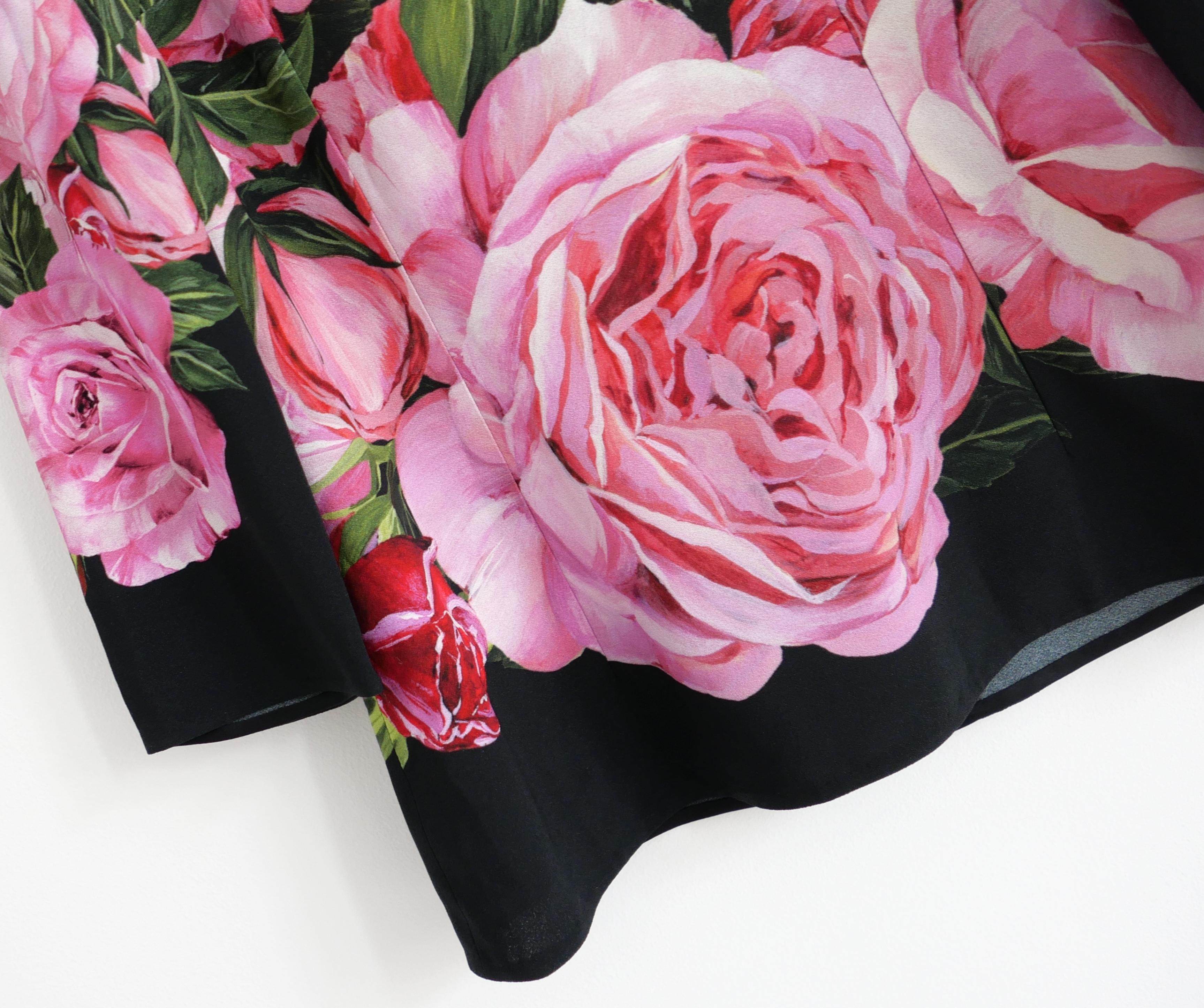 Precioso top con estampado de rosas de Dolce & Gabbana. Se ha usado una vez y se ha limpiado en seco. Confeccionado en viscosa negra con un estampado de rosas rosas a gran escala, tiene un favorecedor corte entallado con cuello redondo, mangas de