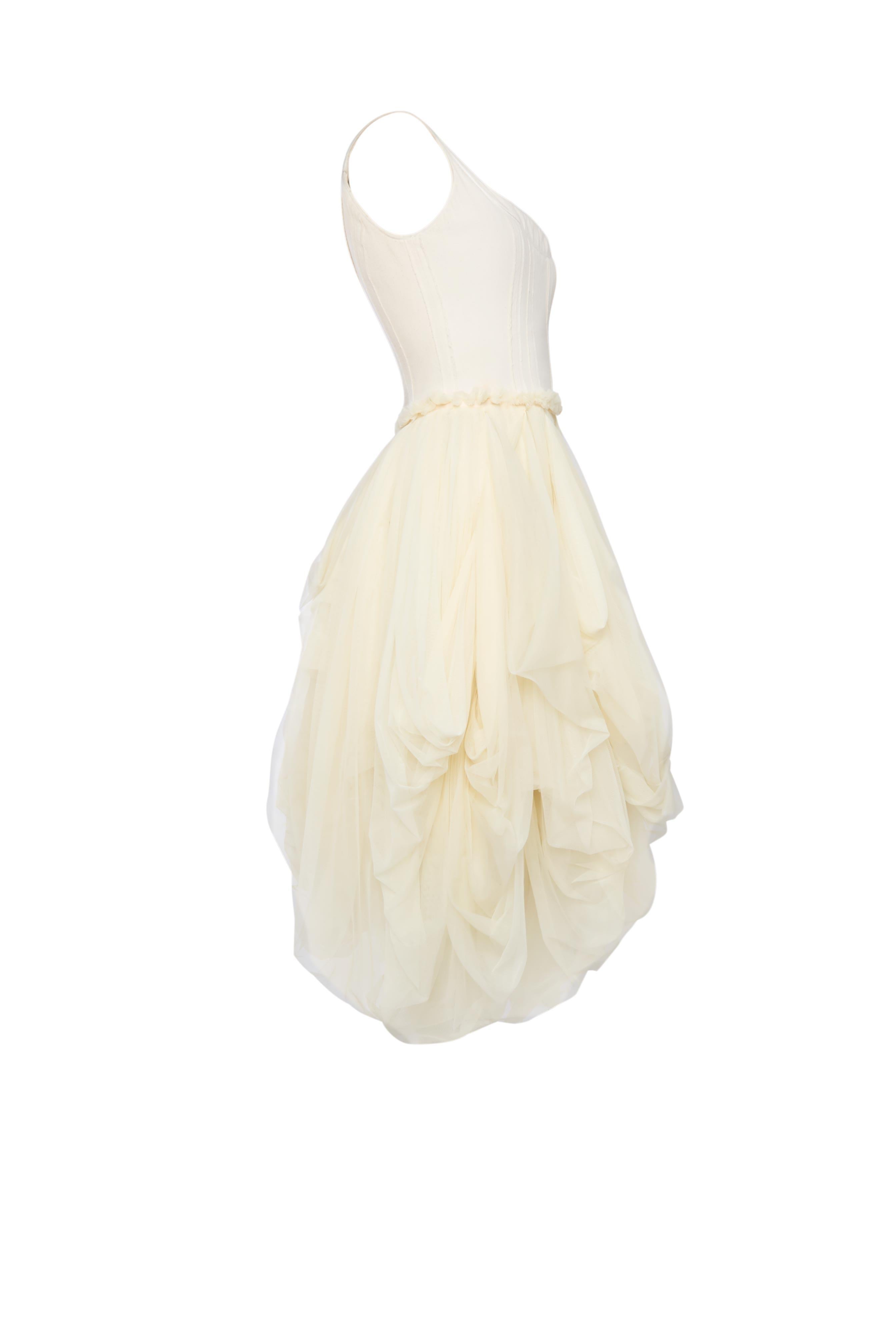 A perfect blend of vintage elegance and 90s grunge, this Dolce & Gabbana dress from the 1994 Spring/Summer collection exudes a unique charm. The ivory tulle gives it a soft, ethereal look, while the structured bodice and voluminous skirt add bold
