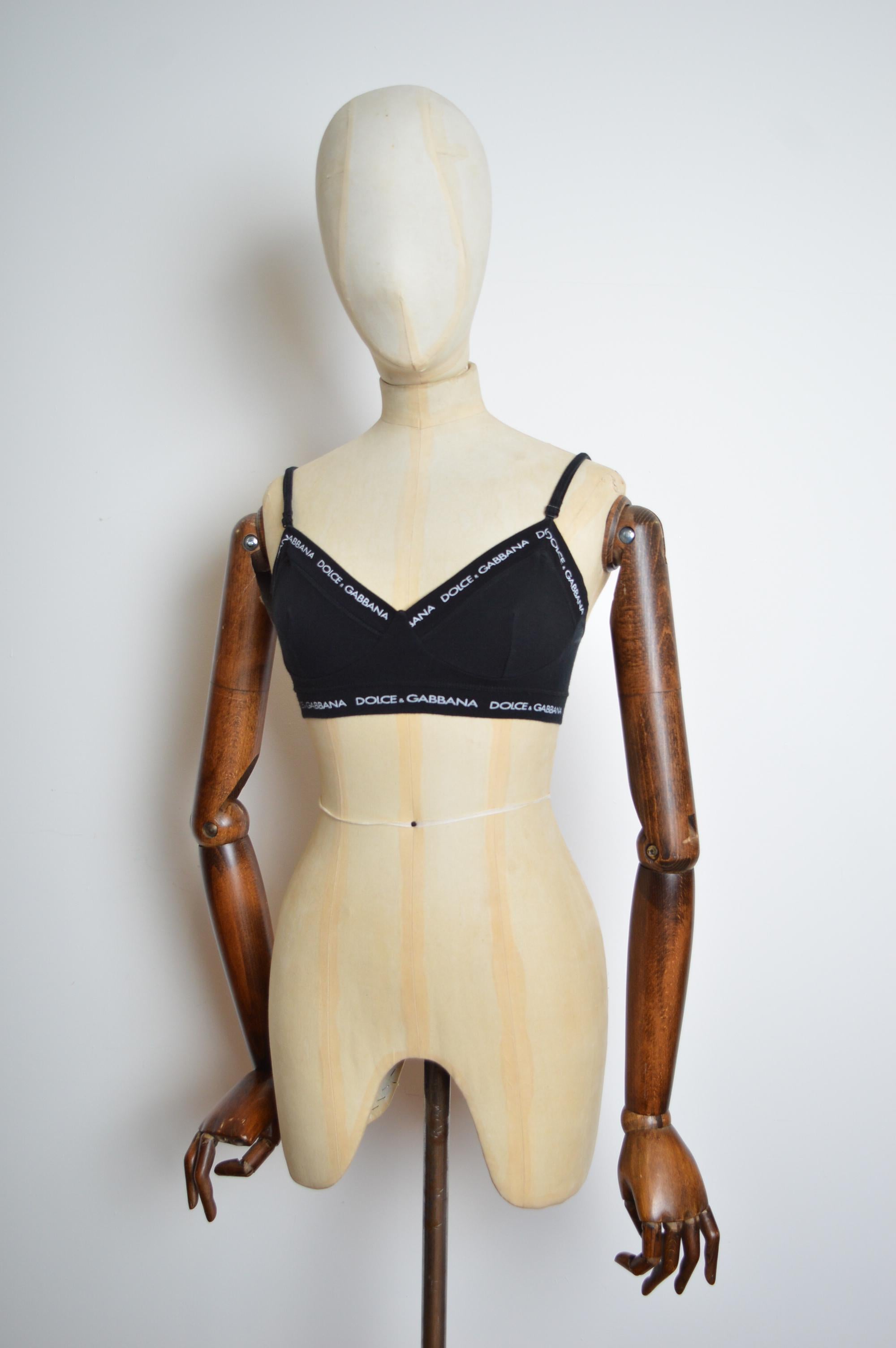 Spring /Summer 1995 Dolce & Gabbana Black Cotton Spell Out Bra Let Crop Top
Features printed Dolce & Gabbana logo throughout. Stretchy cotton sporty fit, fully adjustable shoulder straps, farrier hook closure at the back. 
Produced by LE BONITAS