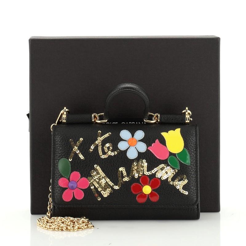 This Dolce & Gabbana Sicily Wallet on Chain Embellished Leather Mini, crafted from black and multicolor embellished leather, features a short top handle, designer plaque, framed top, and gold-tone hardware. Its snap closure opens to a black leather