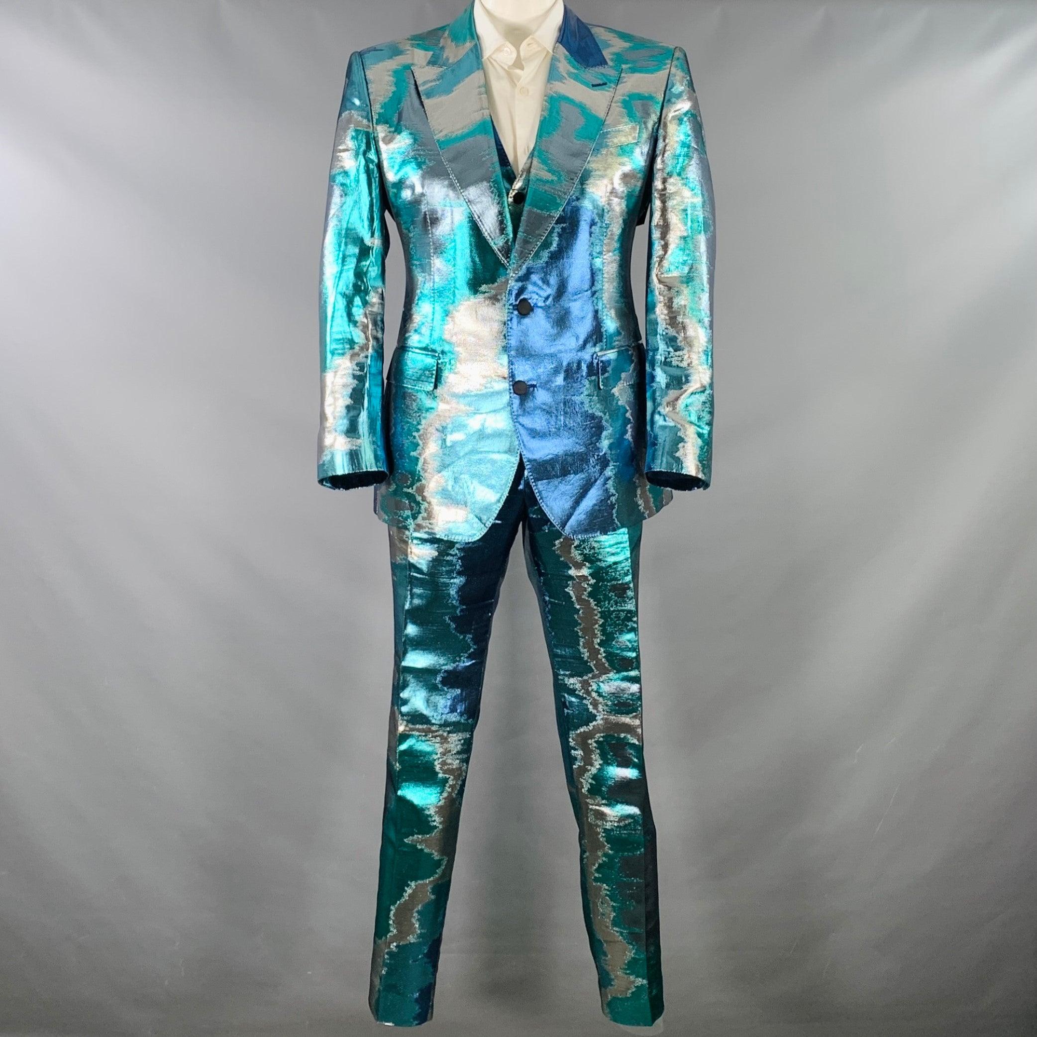 DOLCE & GABBANA Sicilia 3 piece suit
in a metallic blue and silver tone marbled polyester silk blend with a full liner and includes a single breasted, double button sport coat with peak lapel and a matching vest and flat front trousers. Made in