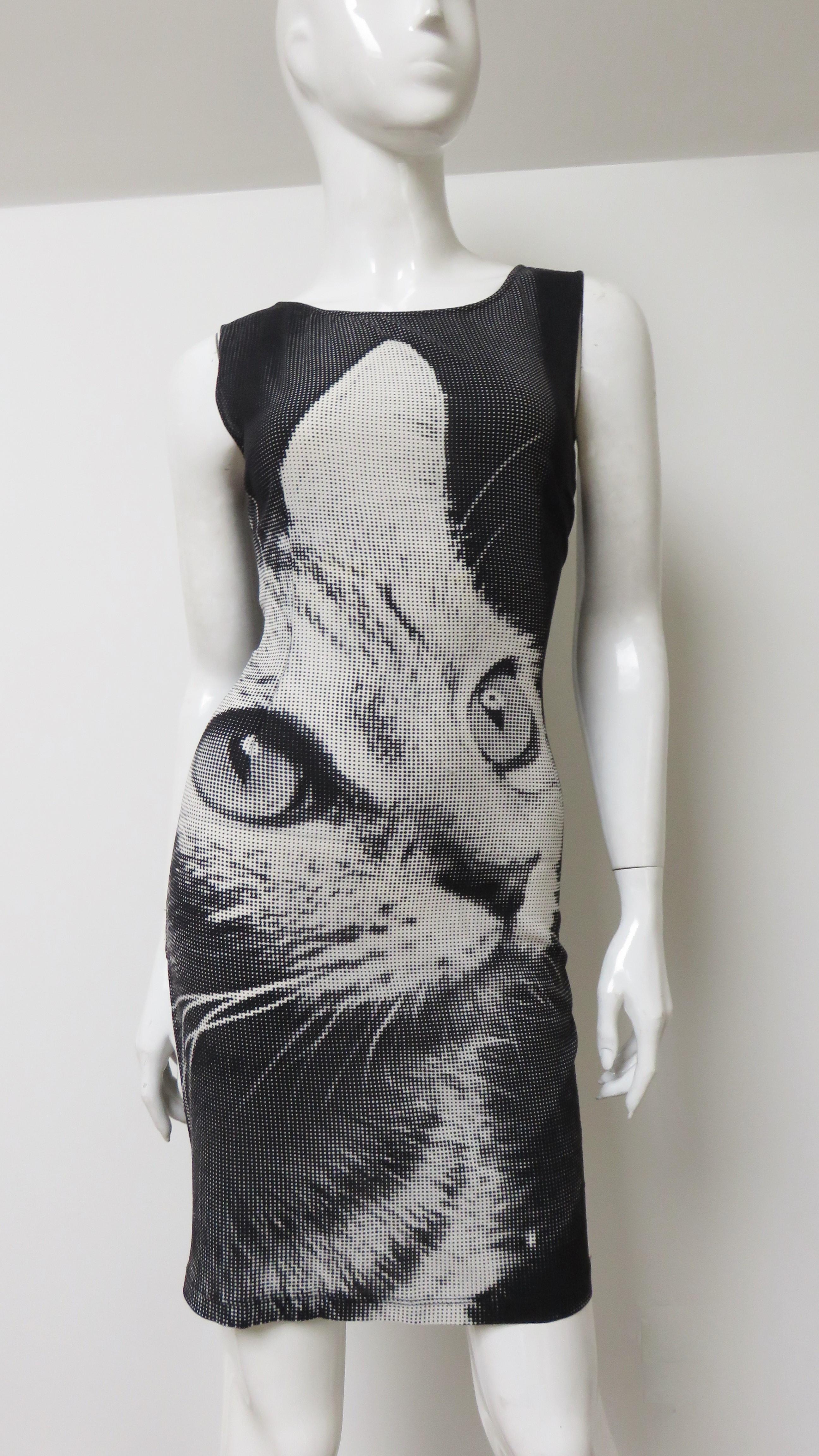 A fabulous silk dress with some stretch from Dolce & Gabbana with a grey, black and white pixelated cat image on the front. it is a sleeveless, fitted dress with a crew neckline and V in the back. It has a center back zipper and is unlined.
Fits
