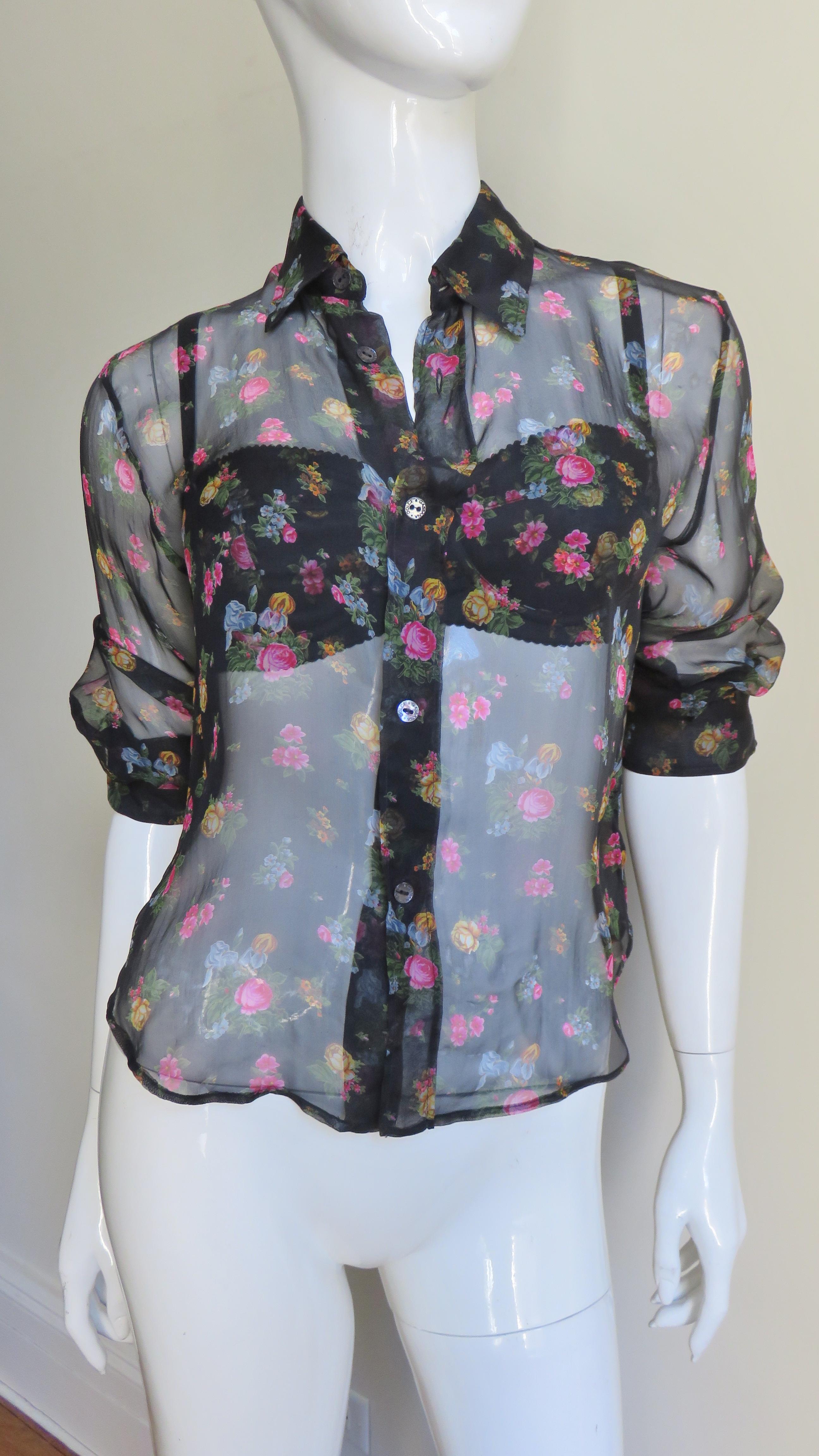 A beautiful set consisting of a bra, shirt and camisole/wrap all in flowered patterned silk on a black background.  The sheer shirt has elbow length sleeves with 2 button cuffs, a small collar, back yoke, and Dolce & Gabbana inscribed mother of