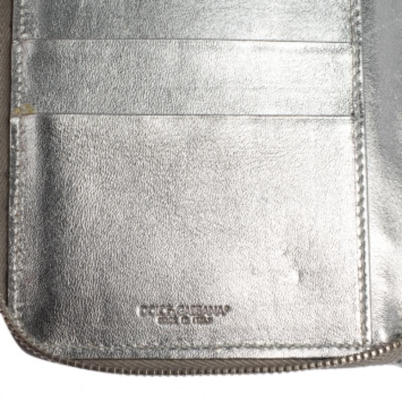 Shiny and handy, this wallet is a Dolce & Gabbana creation. It has been crafted from python-embossed leather, detailed with the DG logo on the front, and equipped with a zipper leading to multiple slots, an open compartment, and a zip pocket for you