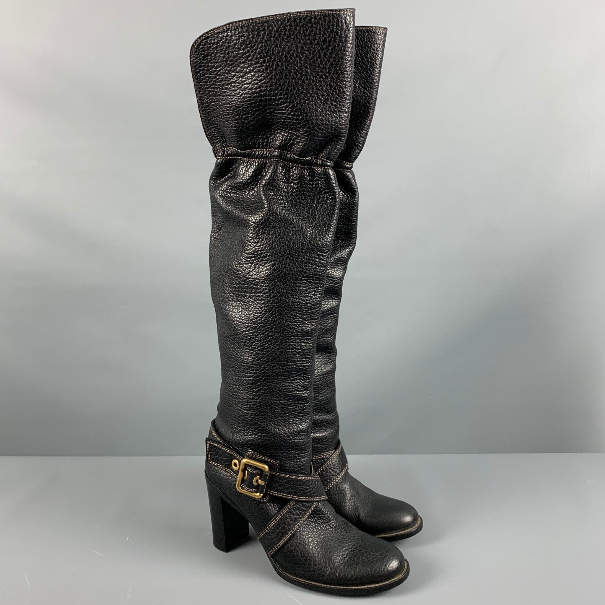DOLCE & GABBANA
boots in a black pebble grain leather featuring an over the knee style, gold tone ankle strap, contrast stitching, and a chunky heel. Made in Italy.Very Good Pre-Owned Condition. Minor signs of wear. 

Marked:   40 

Measurements: 
 