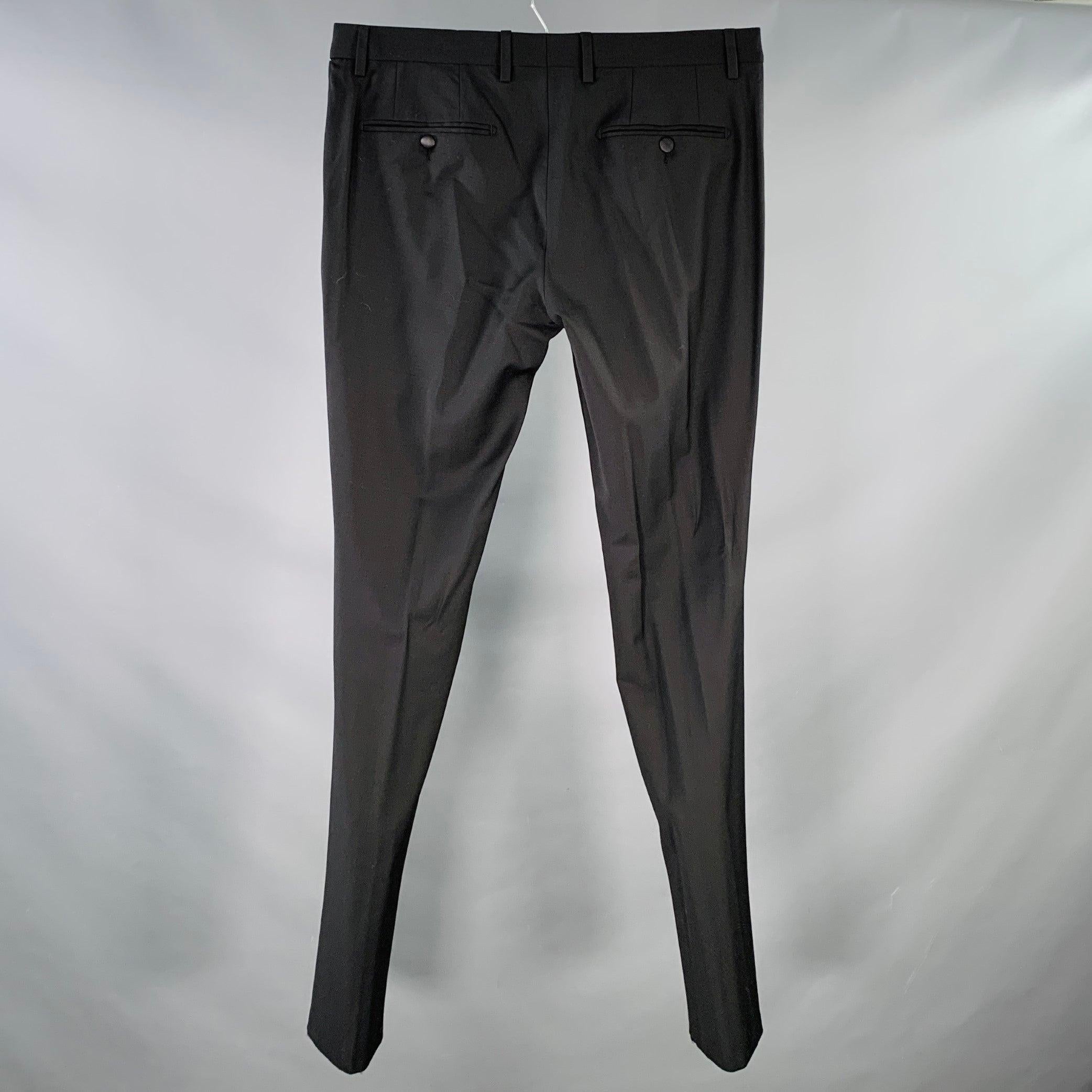 DOLCE & GABBANA dress pants
in a black wool stretch blend fabric featuring a slim tapered leg, flat front, and zip fly closure. Made in Italy.Excellent Pre-Owned Condition. 

Marked:   IT 50 

Measurements: 
  Waist: 34 inches Rise: 9 inches Inseam: