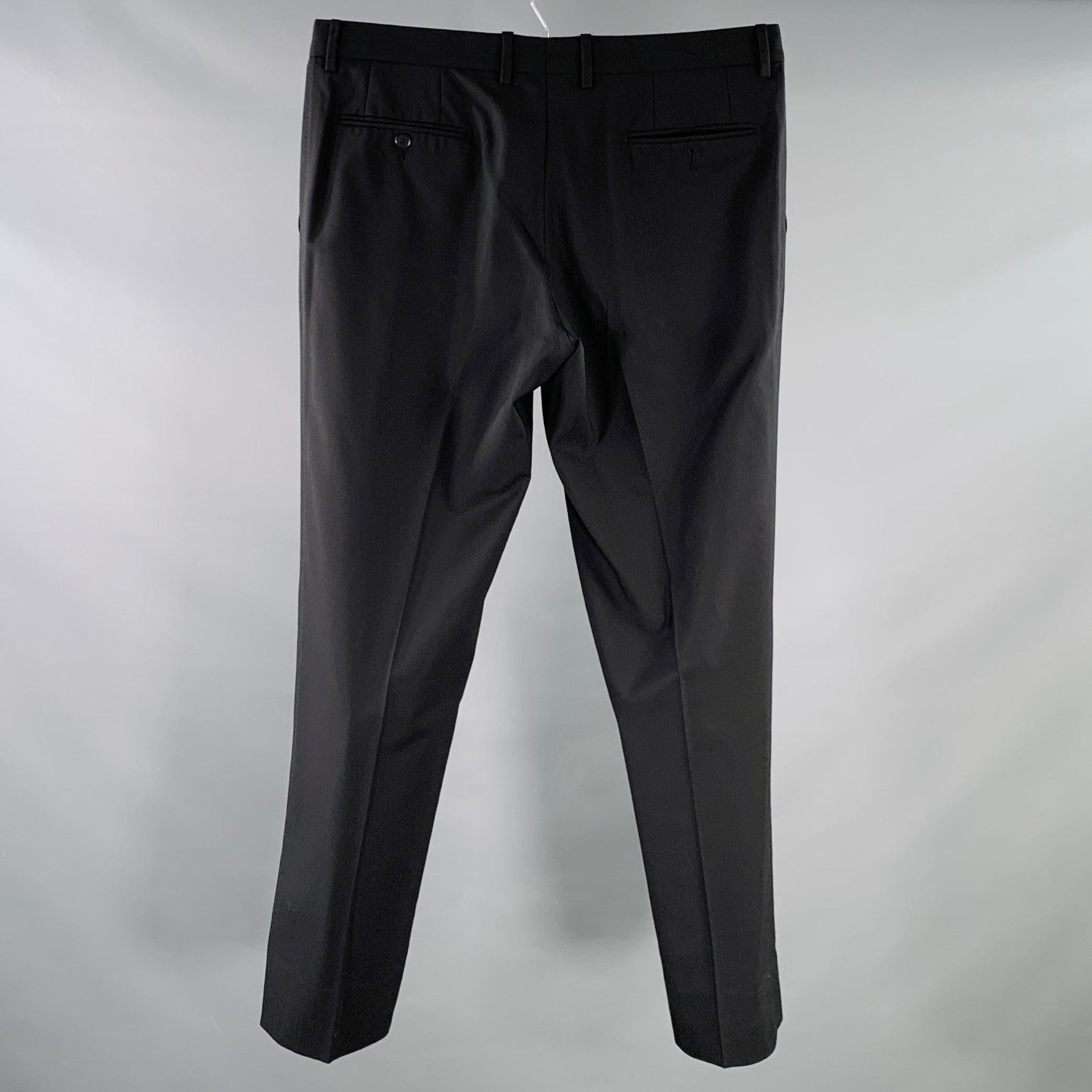 Pantalon habillé DOLCE & GABBANA
en laine mélangée extensible noire, avec un devant plat, une jambe fuselée et une fermeture à glissière. Fabriqué en Italie. Très bon état. Il manque un bouton à la poche arrière. 

Marqué :   IT 50 

Mesures : 
 