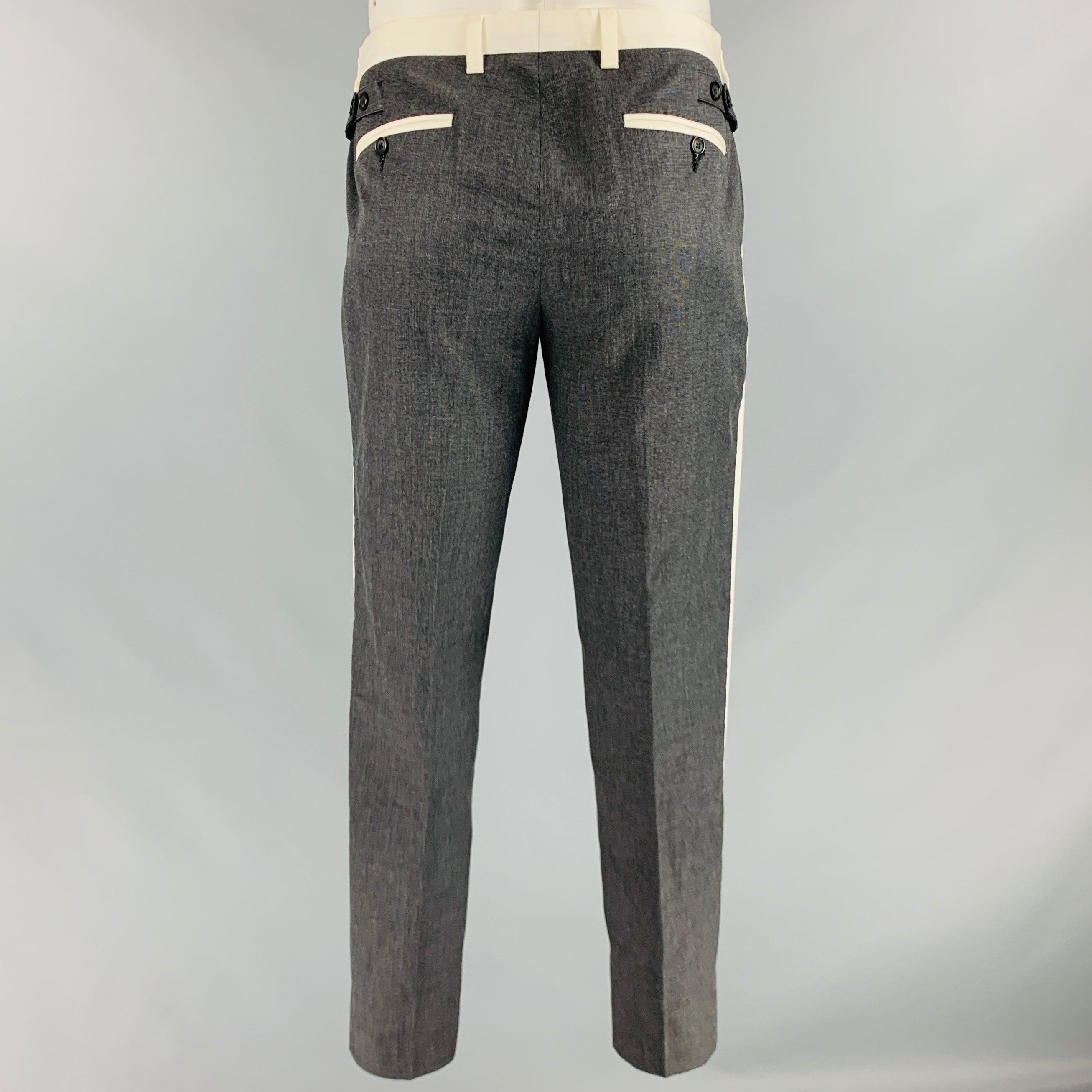 DOLCE & GABBANA tuxedo pants
in a charcoal grey cotton fabric featuring a grid pattern, off white contrast trim, side tabs, and zip fly closure. Made in Italy.Very Good Pre-Owned Condition. Minor marks around waistband and pocket.. 

Marked:   50