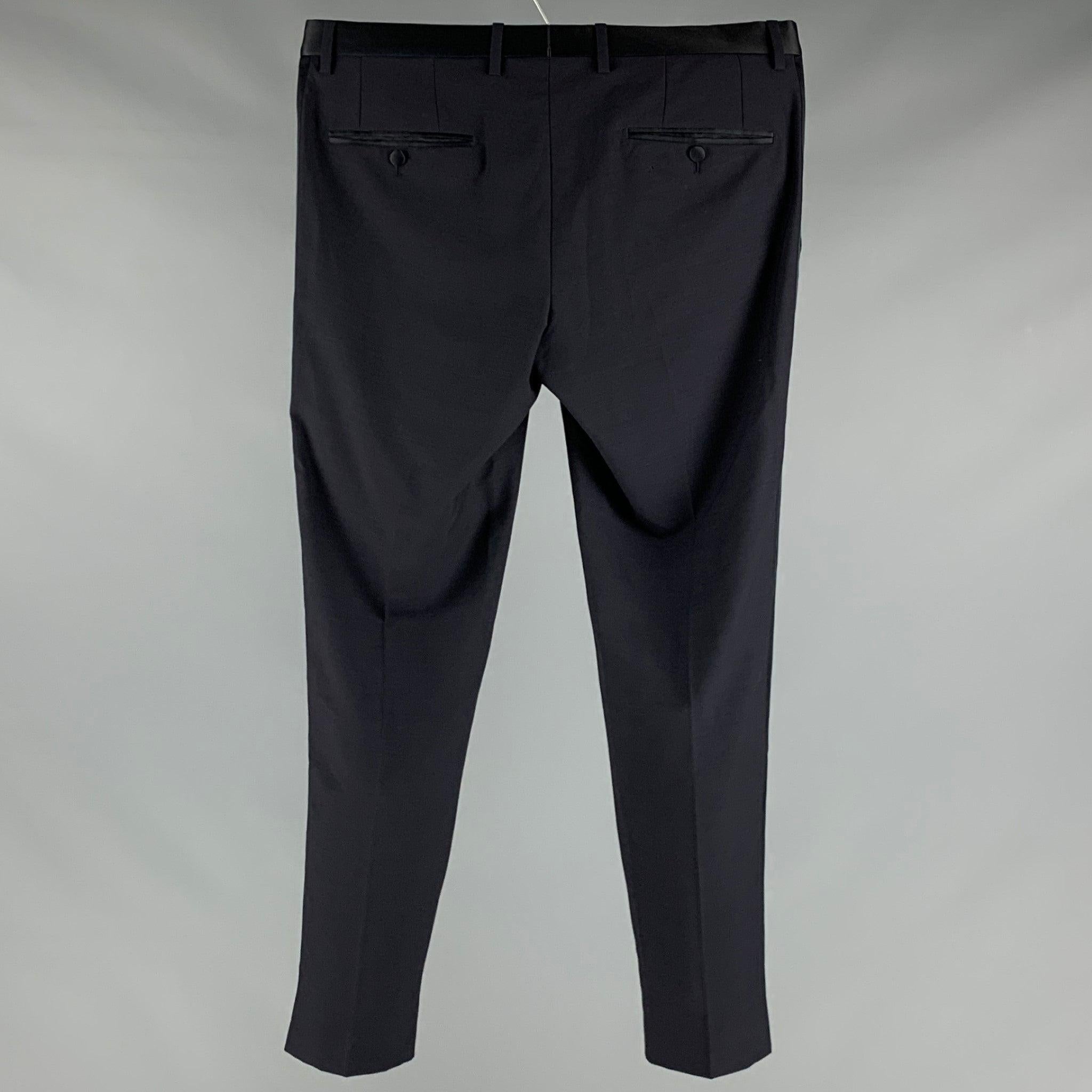 DOLCE & GABBANA tuxedo dress
pants in a navy wool fabric featuring satin waistband and stripes, flat front style, and zip fly closure. Made in Italy.Very Good Pre-Owned Condition. Minor signs of wear. 

Marked:  IT 50 

Measurements: 
 Waist: 34