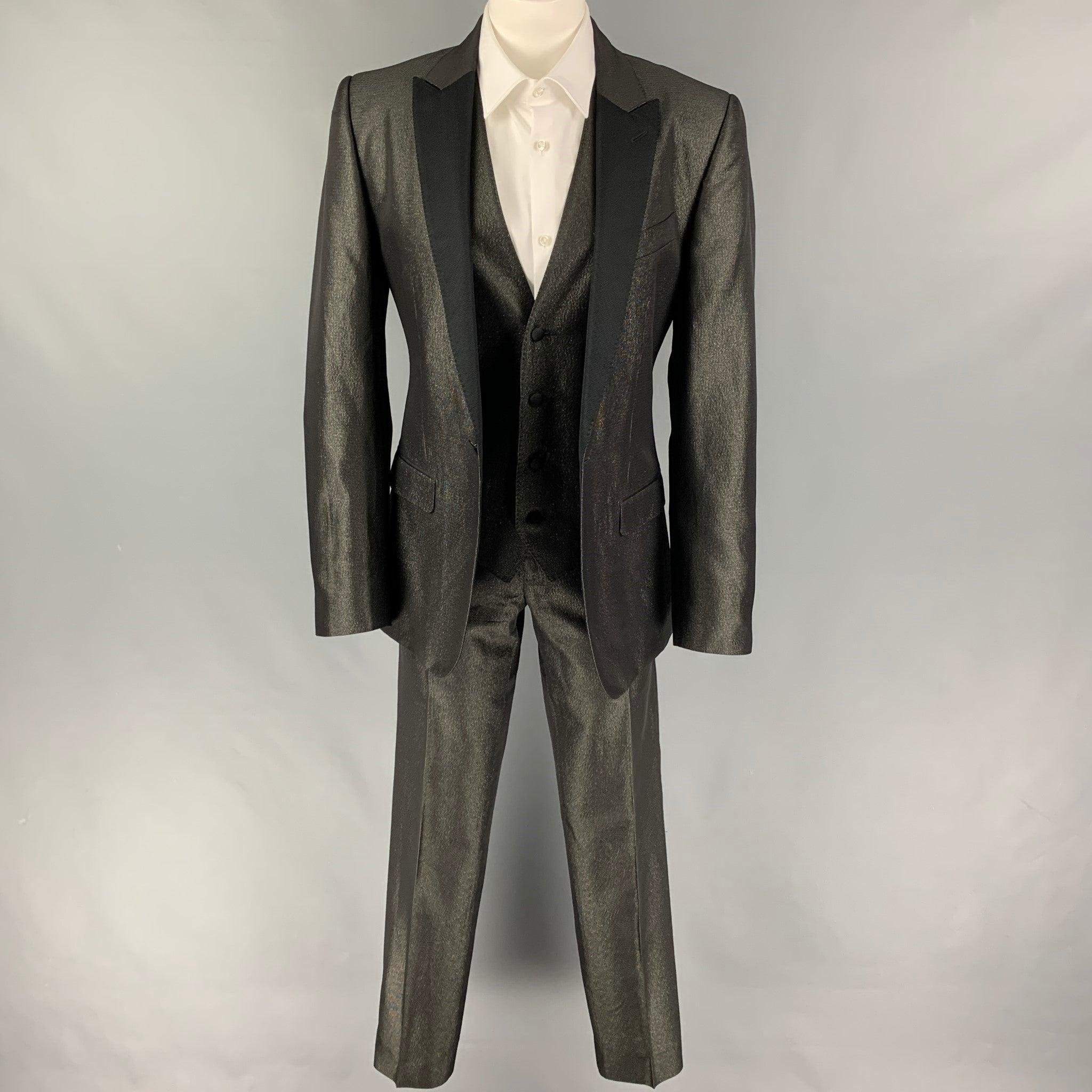 DOLCE & GABBANA 3 Piece Tuxedo
suit comes in a black & gold metallic acetate blend with a full liner and includes a single breasted, one button sport coat with a peak lapel and a matching vest and flat front trousers. Made in Italy. Excellent