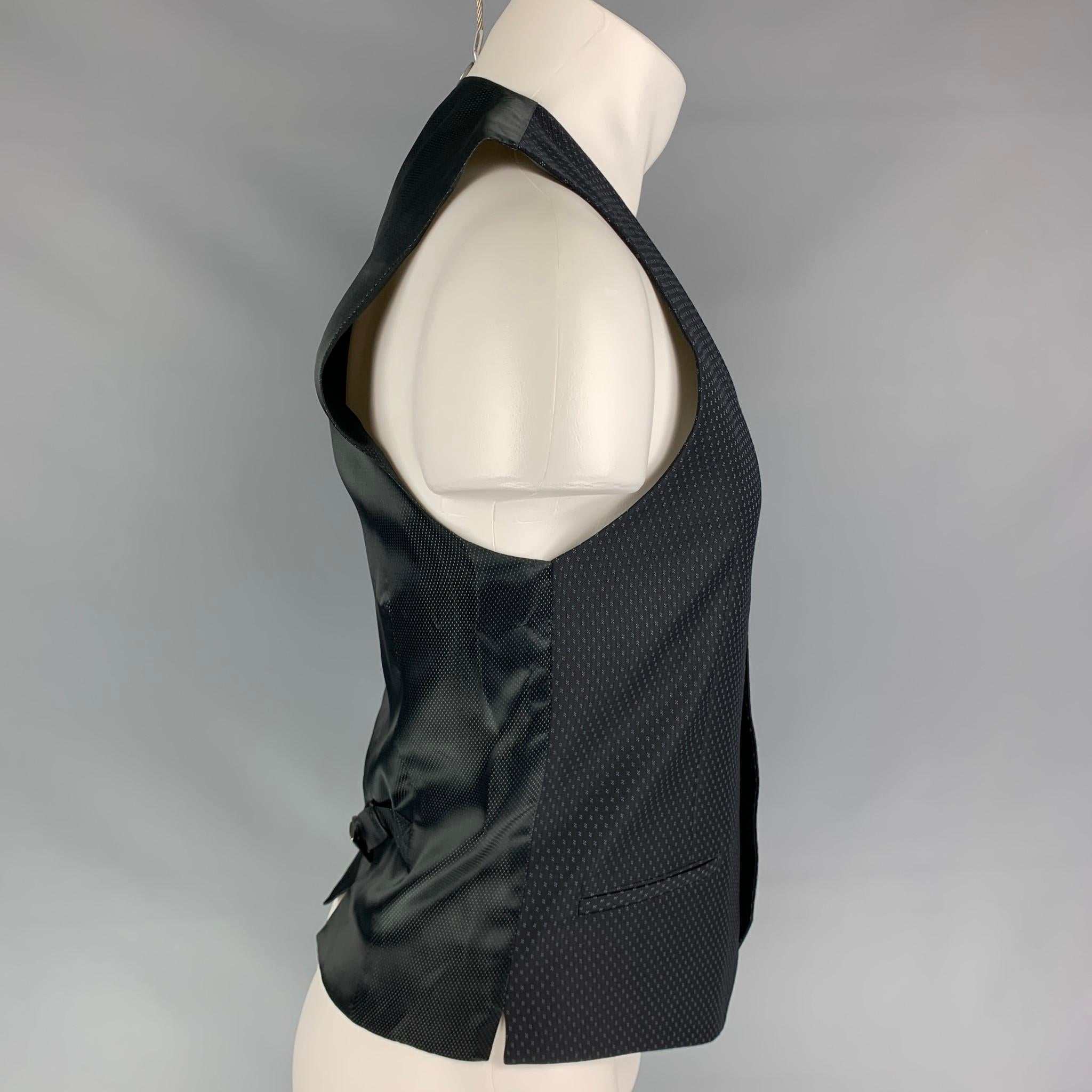 DOLCE & GABBANA vest comes in a black nailhead wool featuring a classic style, back belt, slit pockets, and a buttoned closure. Made in Italy.

Very Good Pre-Owned Condition.
Marked: 46

Measurements:

Shoulder: 13 in.
Chest: 36 in.
Length: 23.5 in.