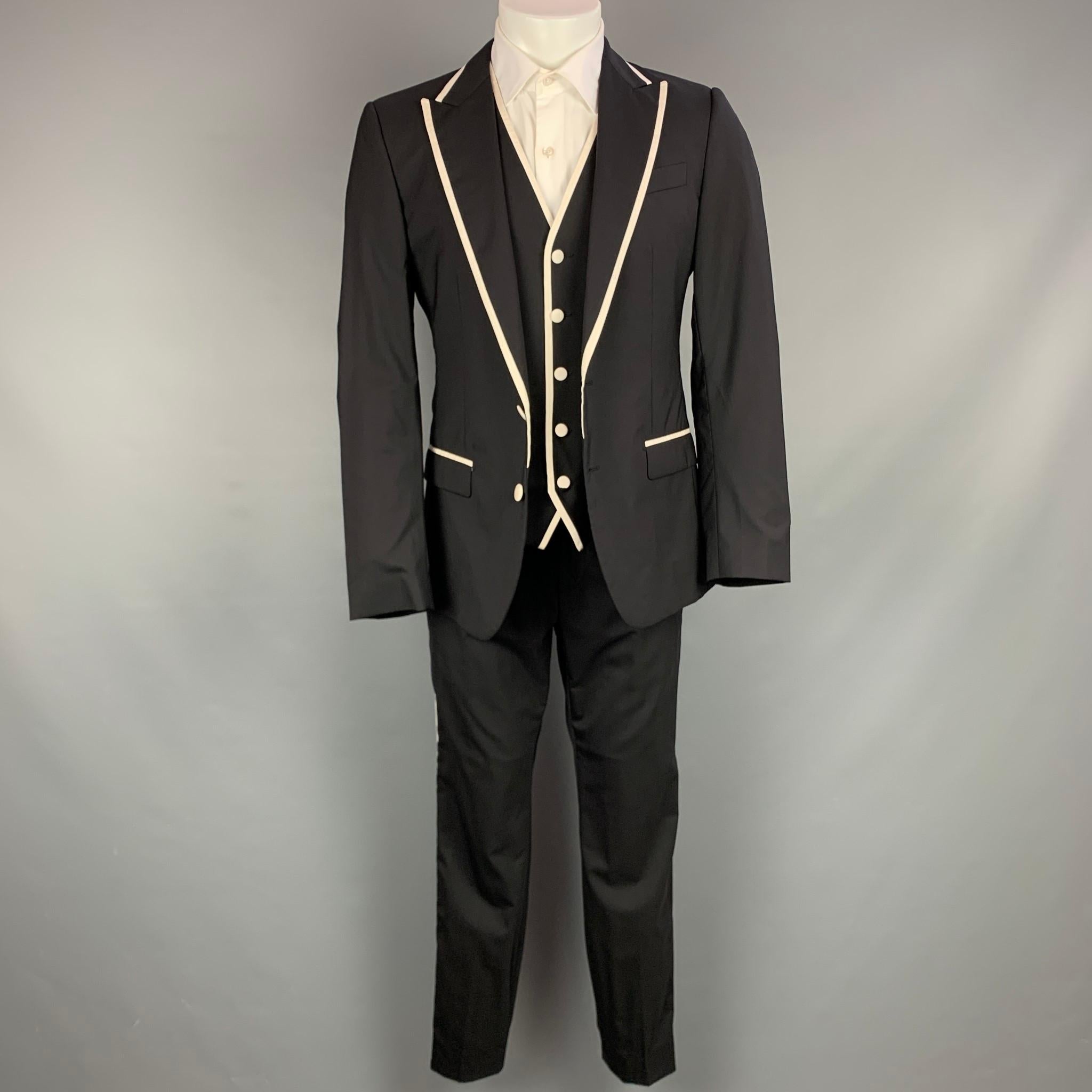DOLCE & GABBANA suit comes in a black & white wool blend with a full liner and includes a single breasted, double button sport coat with peak lapel and matching vest and flat front trousers. Pants have been altered. Made in Italy.

Excellent