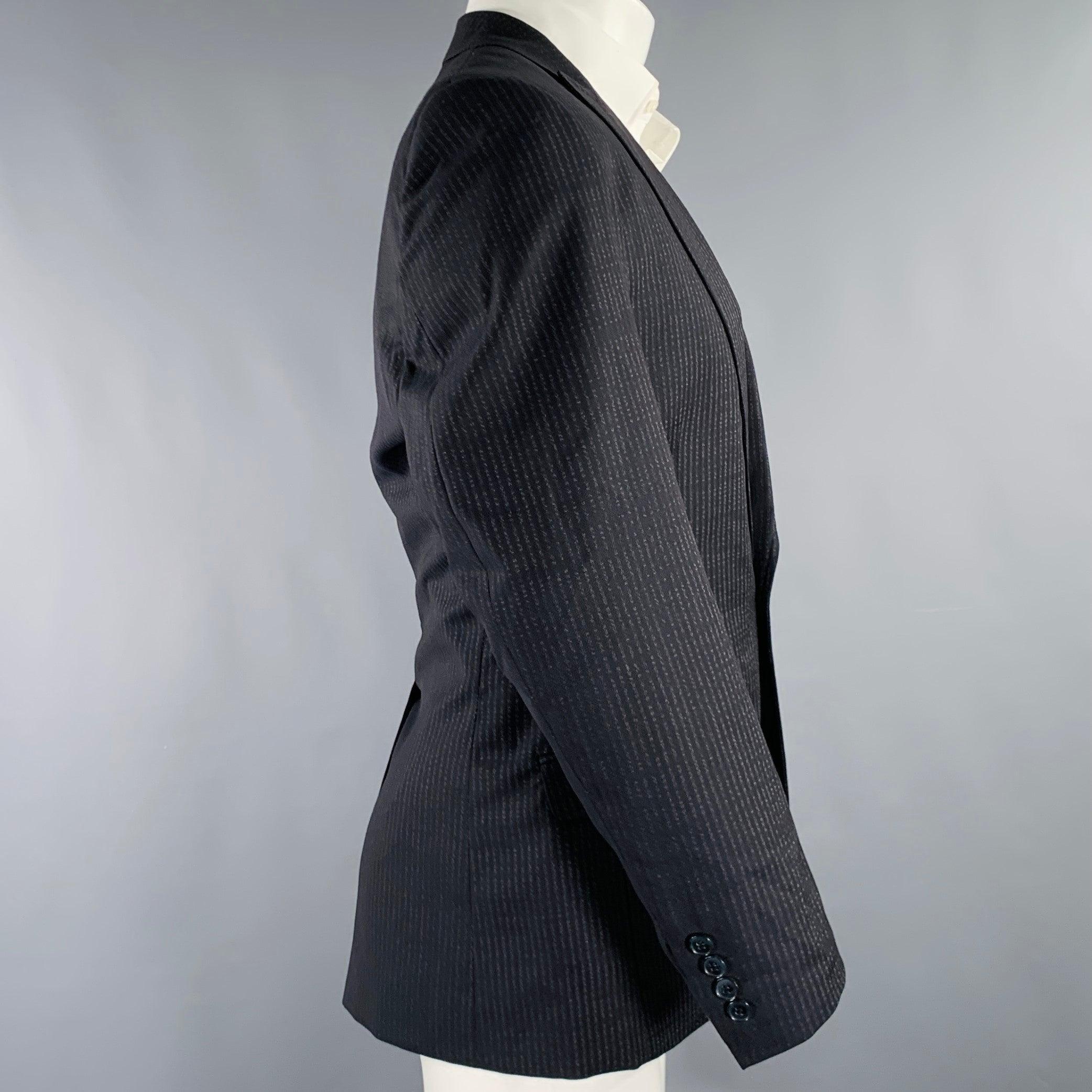 DOLCE & GABBANA sport coat
in a navy virgin wool fabric featuring a stripe pattern, peak lapel, single vented back, and single button closure. Made in Italy.Very Good Pre-Owned Condition. Multiple minor marks. Please check photos. 

Marked:   IT 46