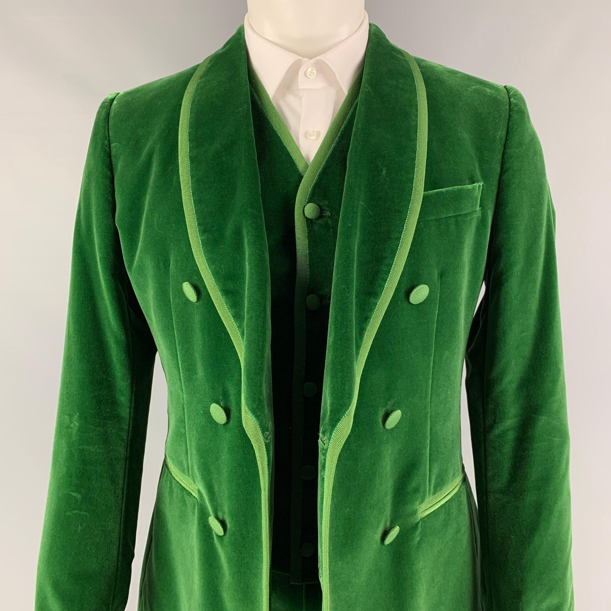 DOLCE & GABBANA 3 Piece
suit comes in a green velvet with a full liner and includes a single breasted button sport coat with a shawl collar and matching flat front trousers. Waist and length of pants need to be altered to size. Made in Italy. New