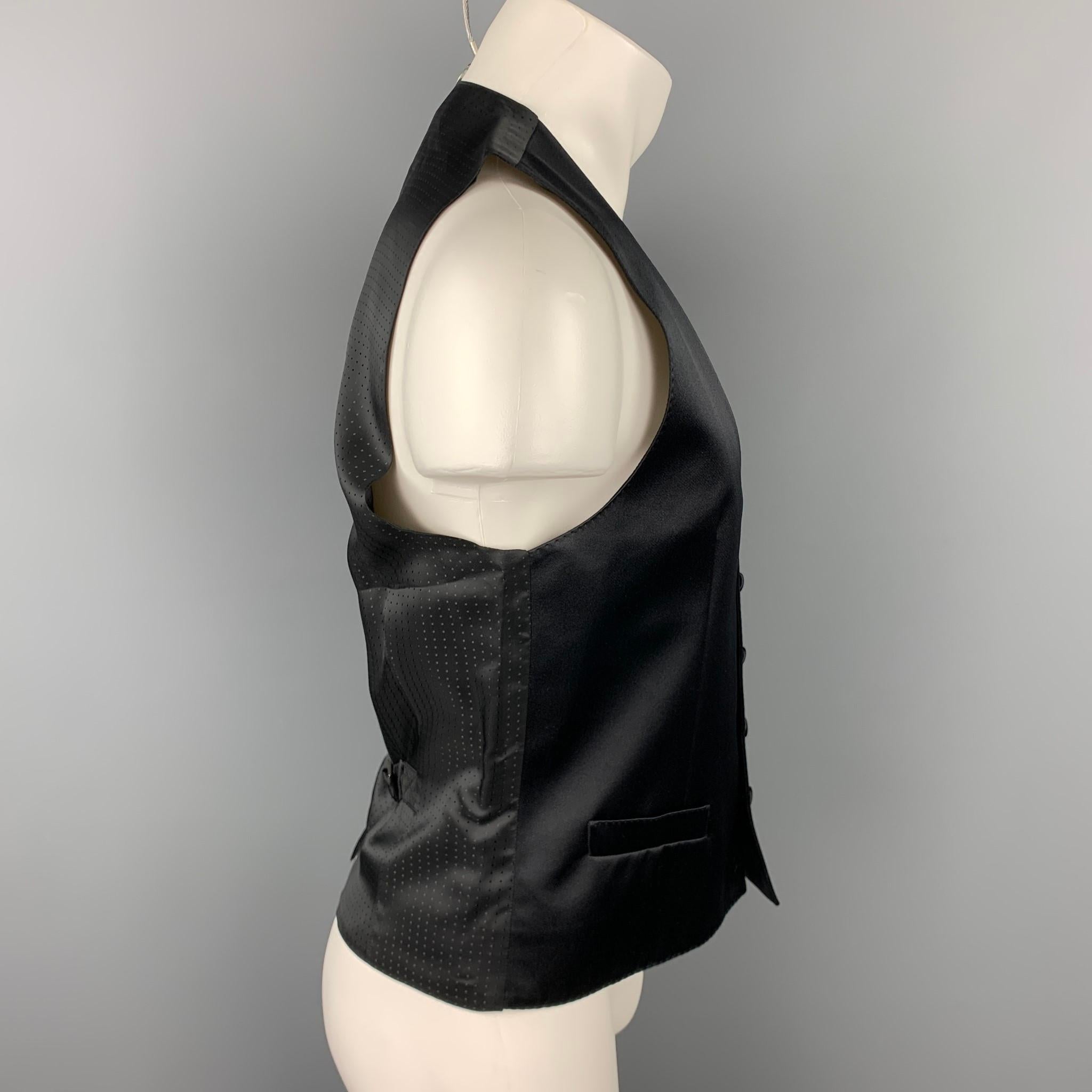 DOLCE & GABBANA dress vest comes in a black silk blend featuring a back belt, slit pockets, and a buttoned closure. Missing button. Made in Italy.

Very Good Pre-Owned Condition.
Marked: IT 48

Measurements:

Shoulder: 14 in. 
Chest: 38 in. 
Length:
