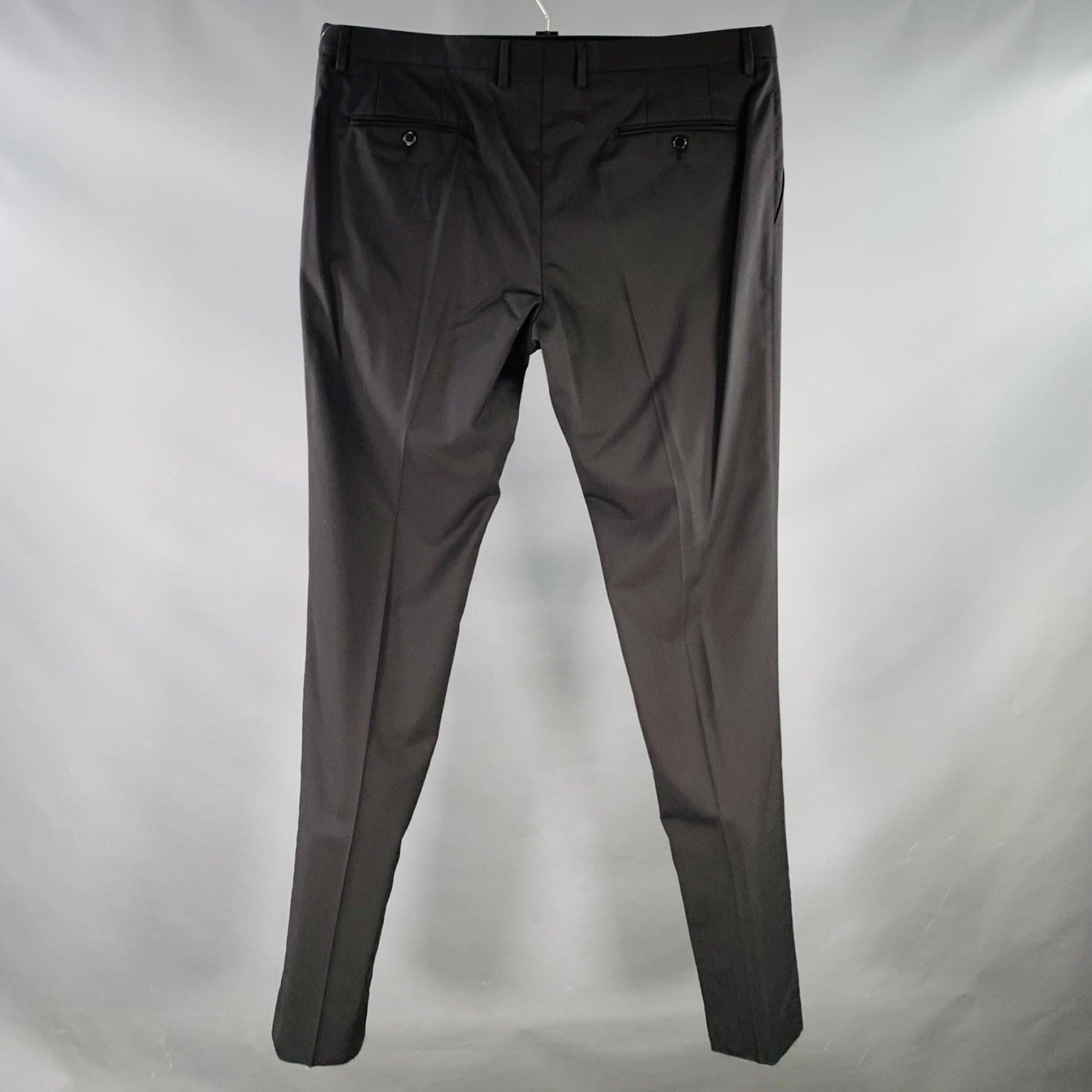 DOLCE & GABBANA dress pants
in a black wool stretch blend fabric featuring a flat front, tapered leg, and zip fly closure. Made in Italy. Hem has been left unfinished to tailor to your perfect fit.Excellent Pre-Owned Condition.  

Marked:   IT 56