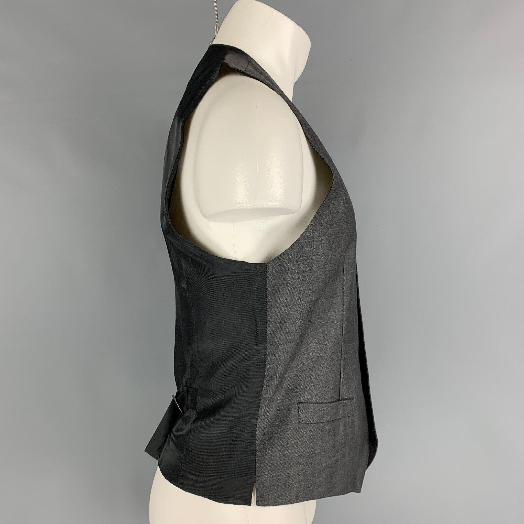 DOLCE & GABBANA
dress vest comes in a dark gray & black wool / silk with a featuring a back belt, front pockets, and a buttoned closure.
Very Good
Pre-Owned Condition. 

Marked:   48 

Measurements: 
 
Shoulder: 13.5 inches  Chest: 38 inches 
