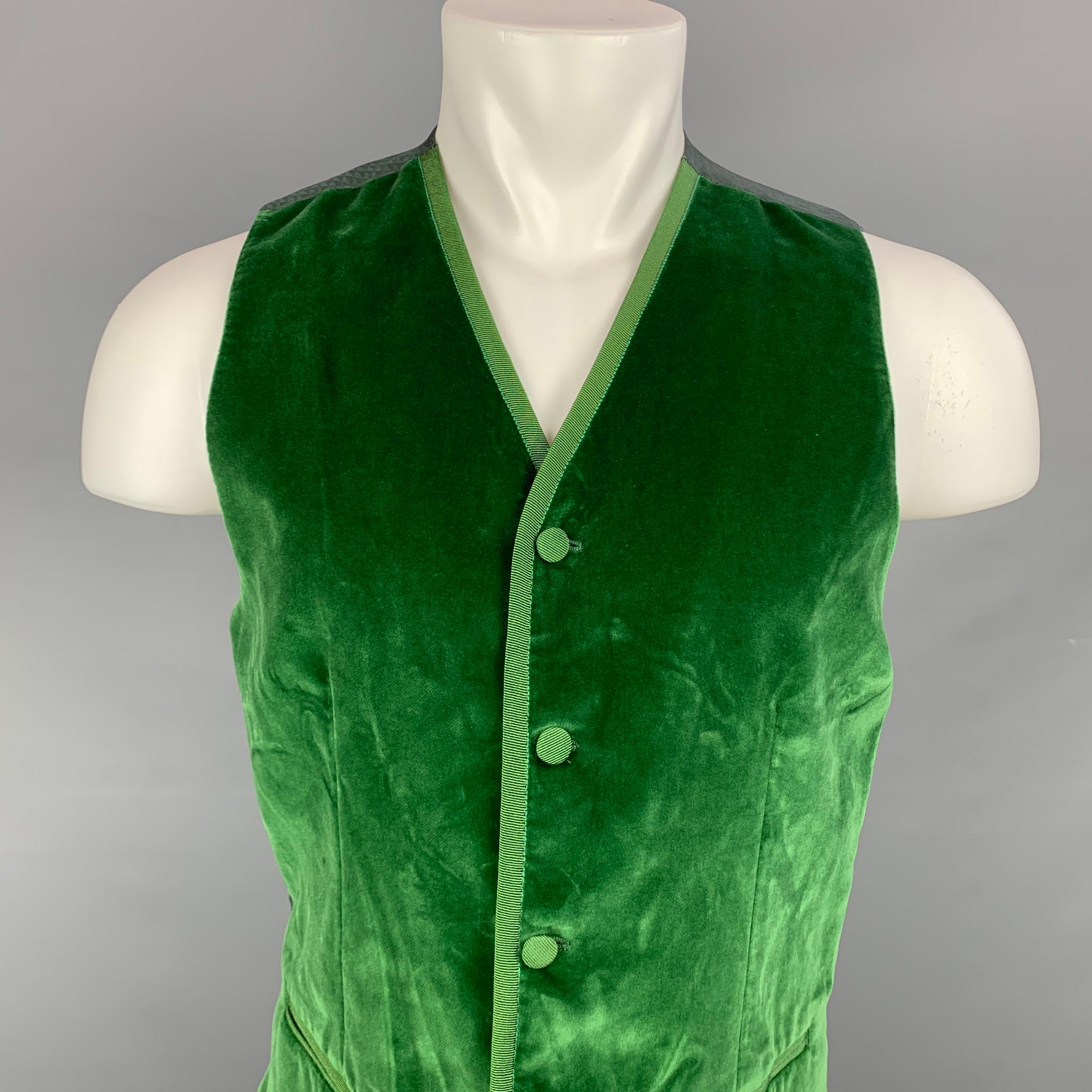 DOLCE & GABBANA vest comes in a green velvet featuring a back belt, slit pockets, and a covered buttoned closure. Made in Italy.

Very Good Pre-Owned Condition.
Marked: IT 48

Measurements:

Shoulder: 13.5 in.
Chest: 38 in.
Length: 23.5 in. 
