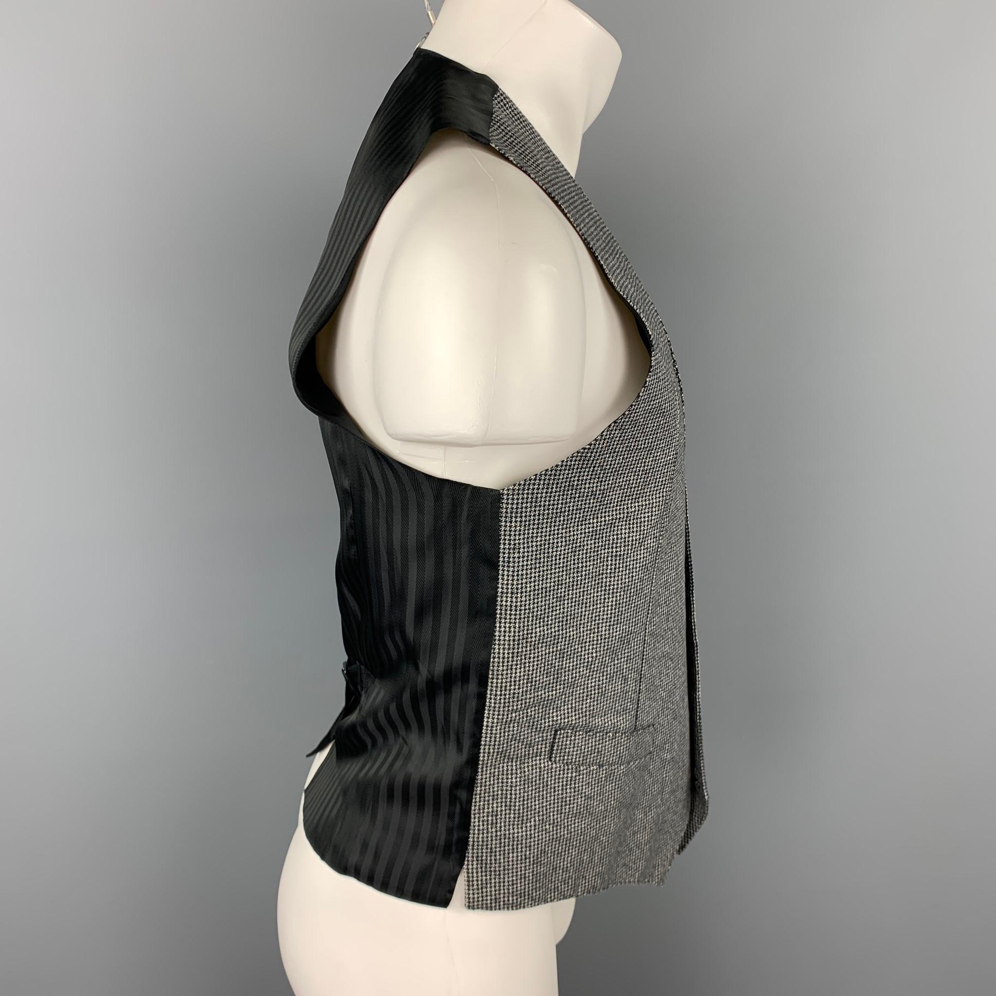 DOLCE & GABBANA dress vest comes in a grey & black houndstooth cotton featuring a back belt, slit pockets, and a buttoned closure. Made in Italy.

Excellent Pre-Owned Condition.
Marked: IT 48

Measurements:

Shoulder: 13.5 in. 
Chest: 38 in.