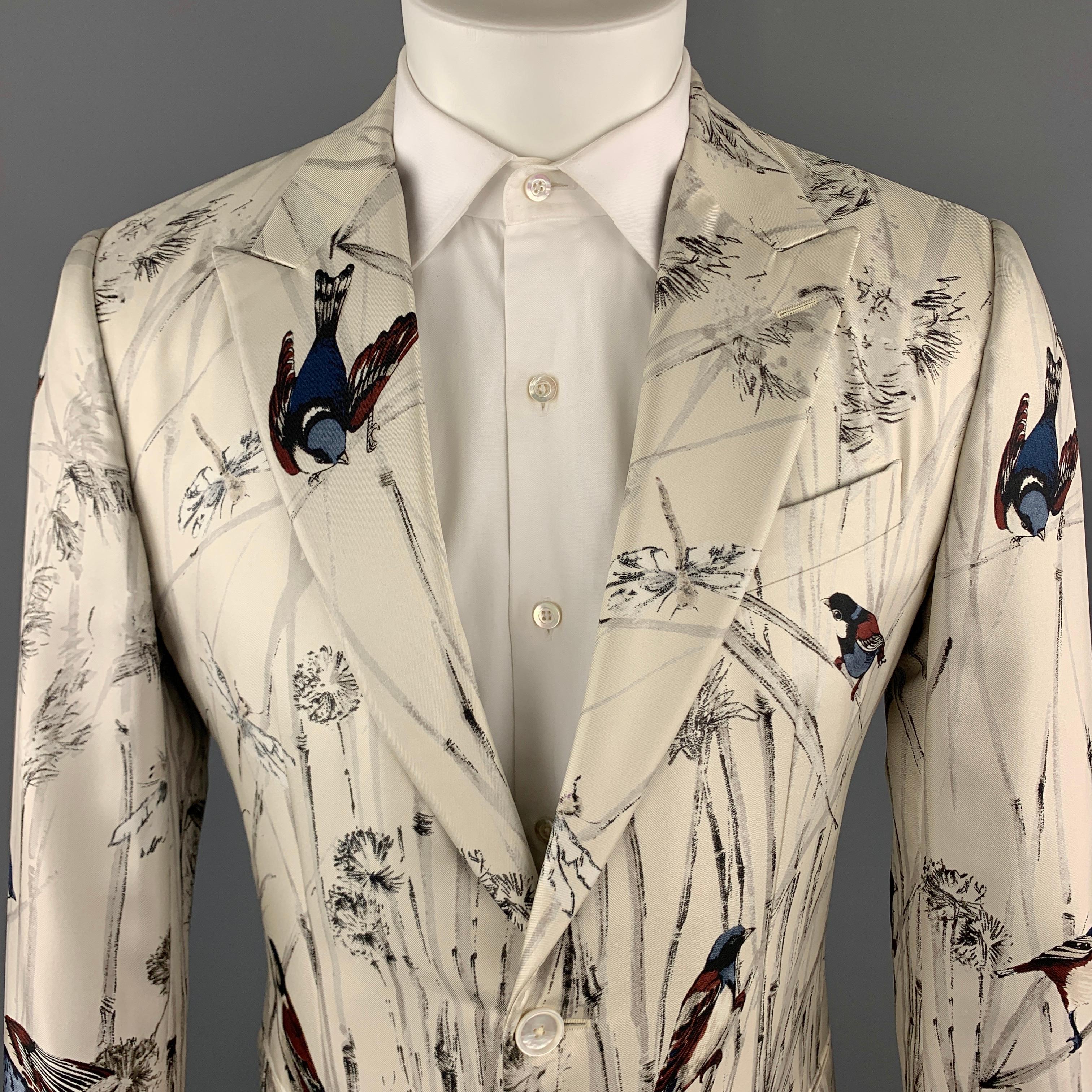 DOLCE & GABBANA Sport Coat comes in an ivory birds print silk material, with a peak lapel, slit pockets, two buttons at closure, single breasted, functional buttons at cuffs, and a single vent at back. Made in Italy. 

New with Tags.
Marked: IT