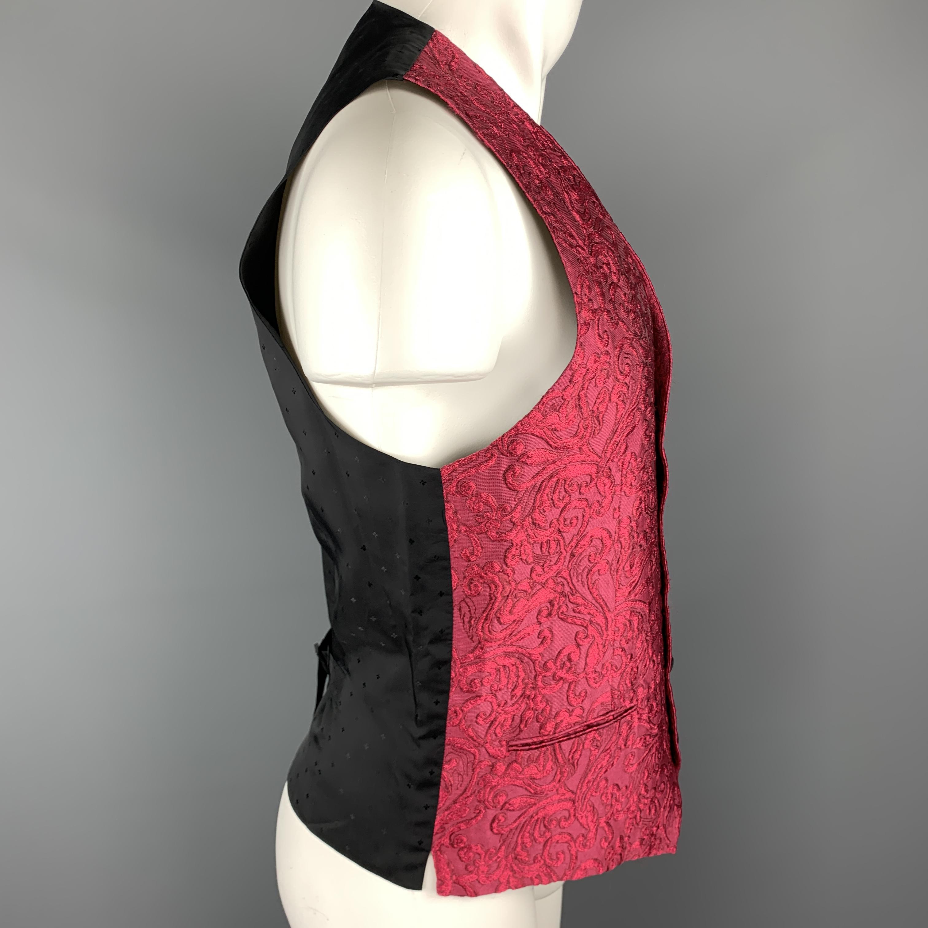 DOLCE & GABBANA vest comes in a bold raspberry fuchsia brocade with a V neck, black faille button front, and patterned satin back. Made in Italy.

Excellent Pre-Owned Condition.
Marked: IT 48

Measurements:

Shoulder: 13 in.
Chest: 38 in.
Length: 26