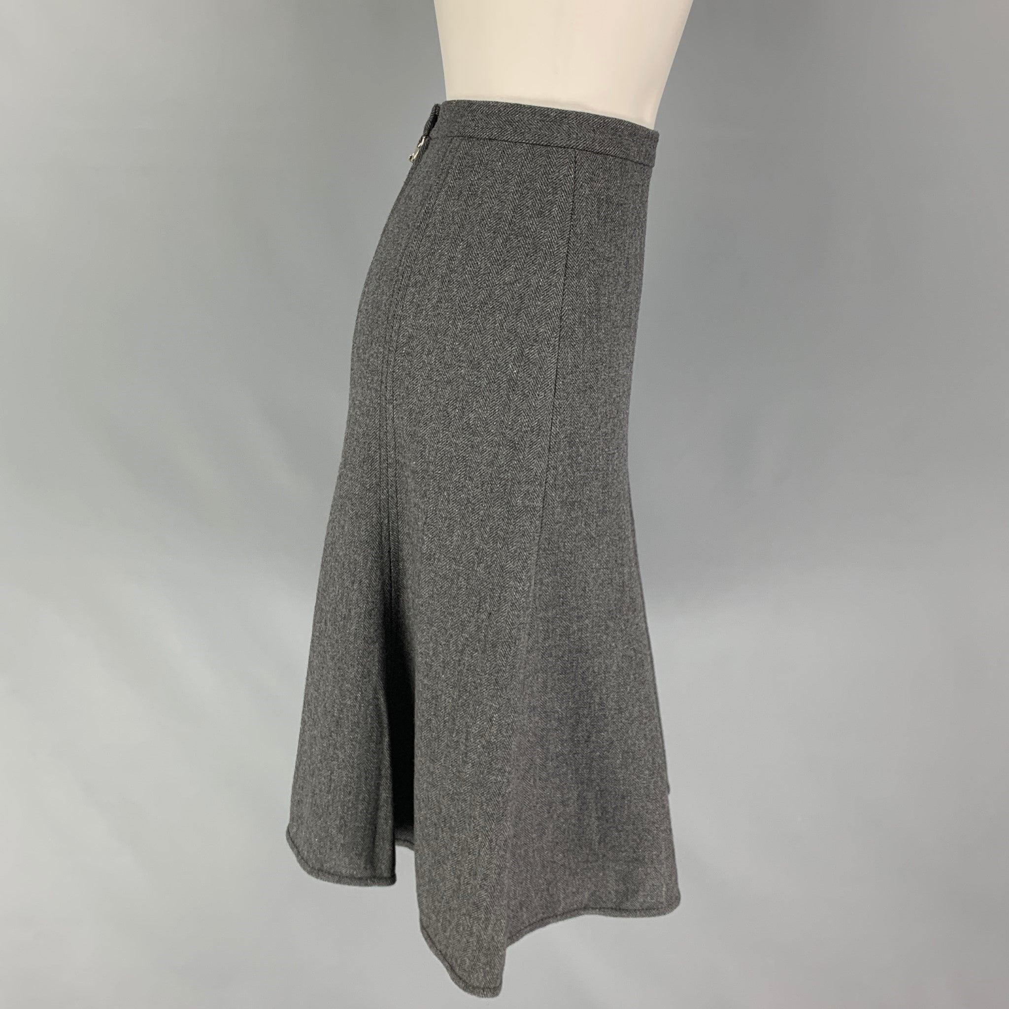 DOLCE & GABBANA skirt comes in a grey herringbone wool blend with a animal print interior featuring a tulip style, snap button detail, and a back zipper closure. Made in Italy.Very Good
Pre-Owned Condition. 

Marked:   40 

Measurements: 
  Waist: