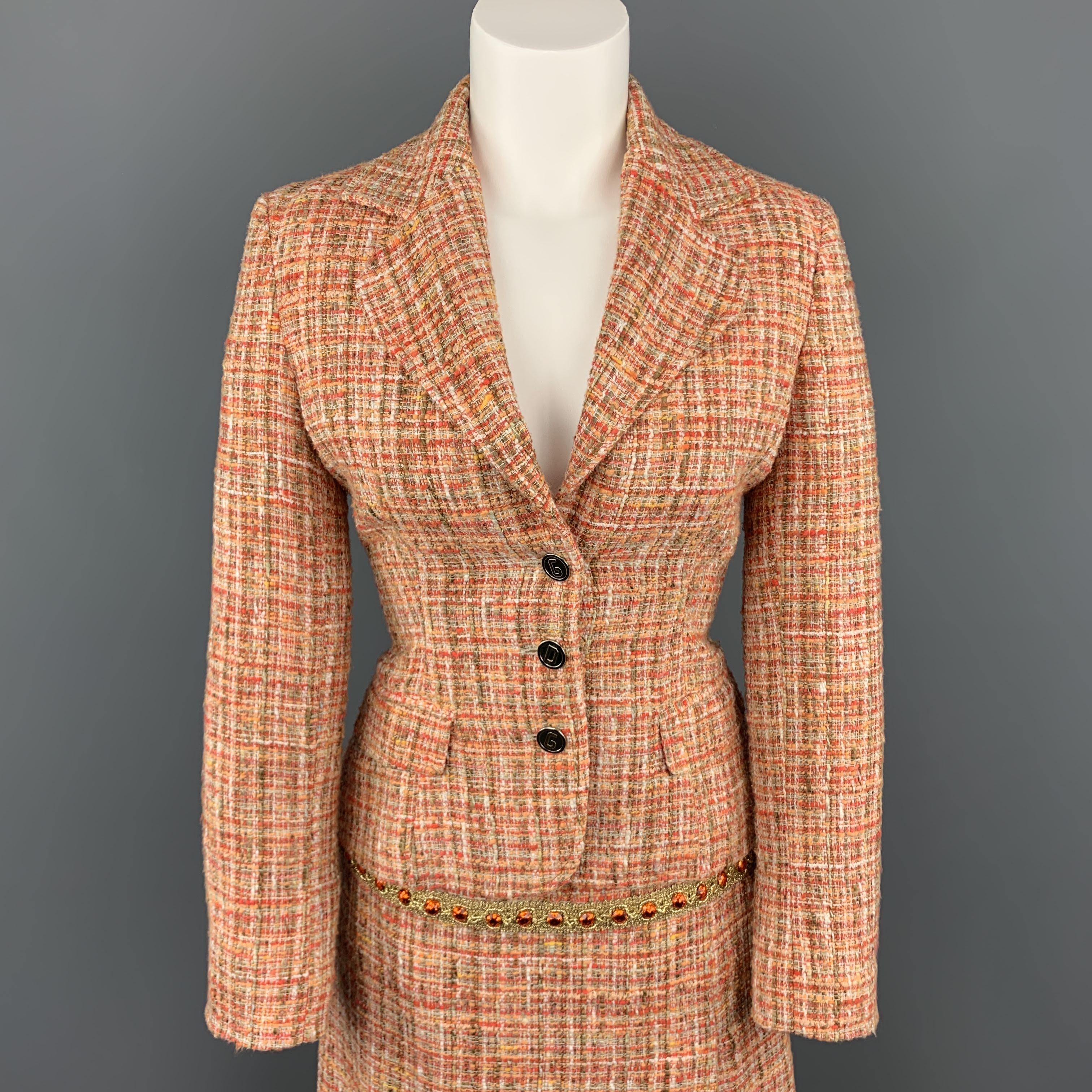 Vintage DOLCE & GABBANA suit comes in orange cotton blend tweed and includes a cropped blazer with metal D G buttons and notch lapel with matching slit pencil skirt embellished with orange jewels. Made in Italy.
 
Excellent Pre-Owned
