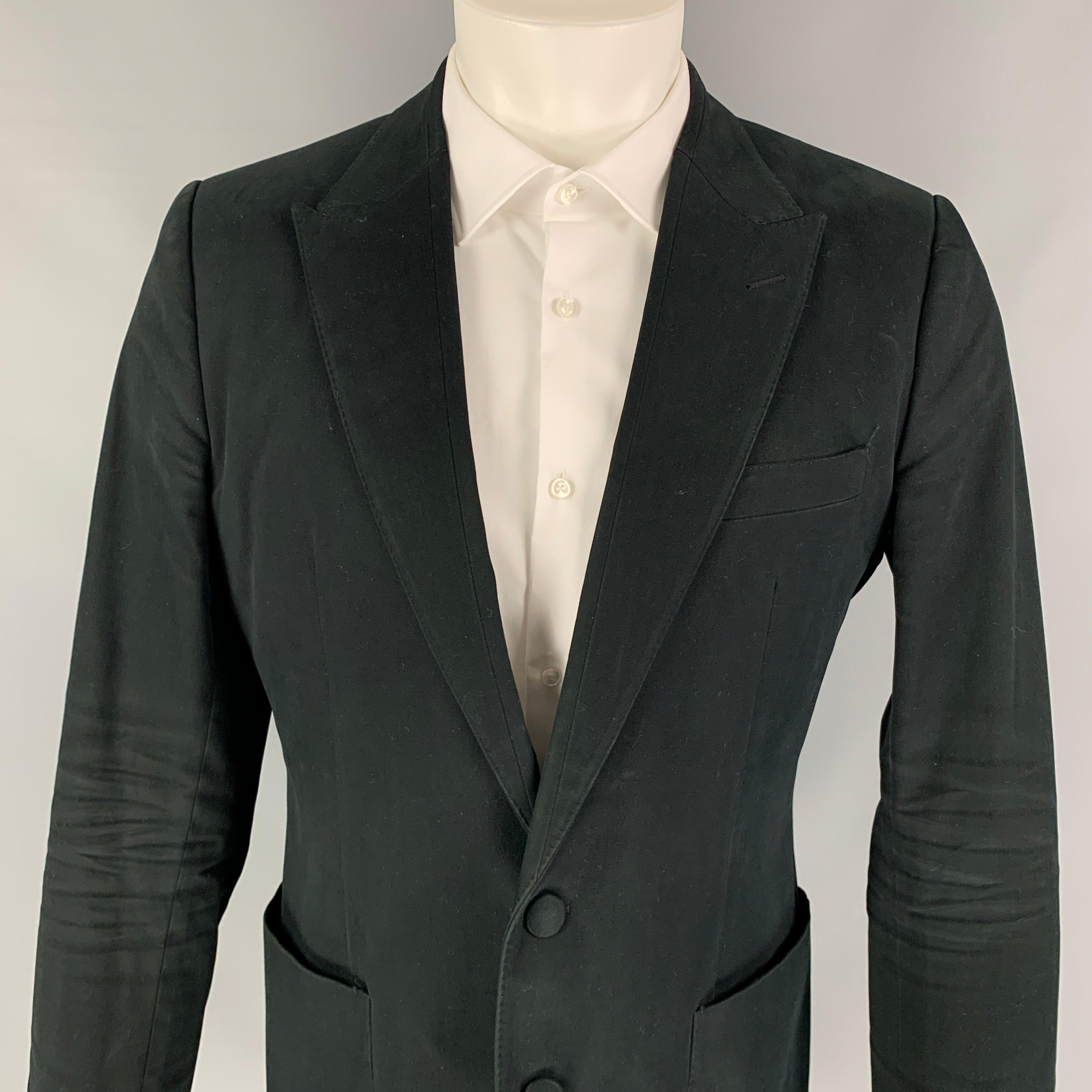 DOLCE & GABBANA sport coat comes in a black cotton with a half liner featuring a peak lapel, patch pockets, single back vent, and a double button closure. Made in Italy.
Very Good
Pre-Owned Condition. 

Marked:   50 

Measurements: 
 
Shoulder: 17.5
