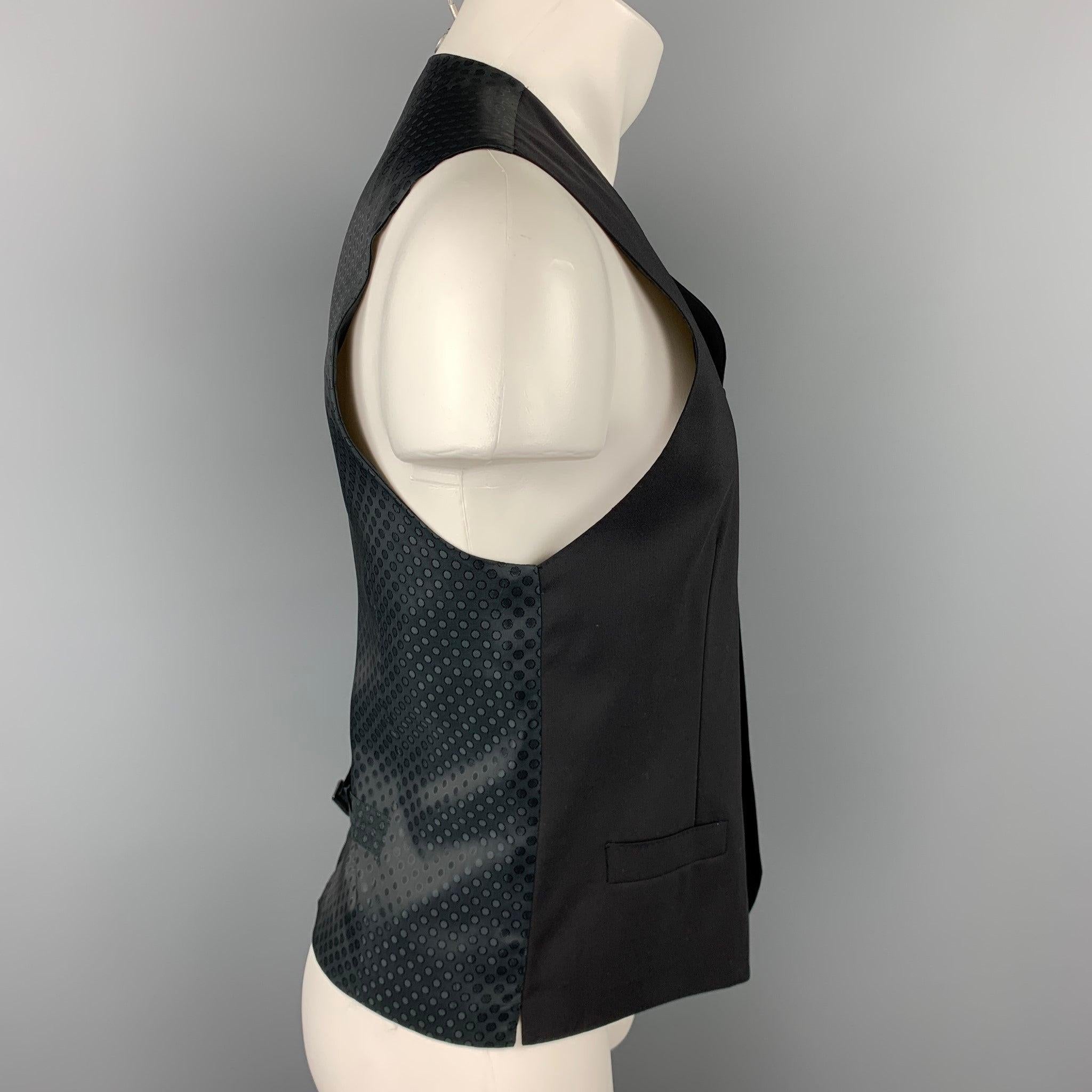 DOLCE & GABBANA dress vest comes in a black wool featuring a back belt, slit pockets, and a buttoned closure. Made in Italy.Very Good
Pre-Owned Condition. 

Marked:   IT 50 

Measurements: 
 
Shoulder: 15 inches 
Chest: 40 inches Length: 23 inches 
