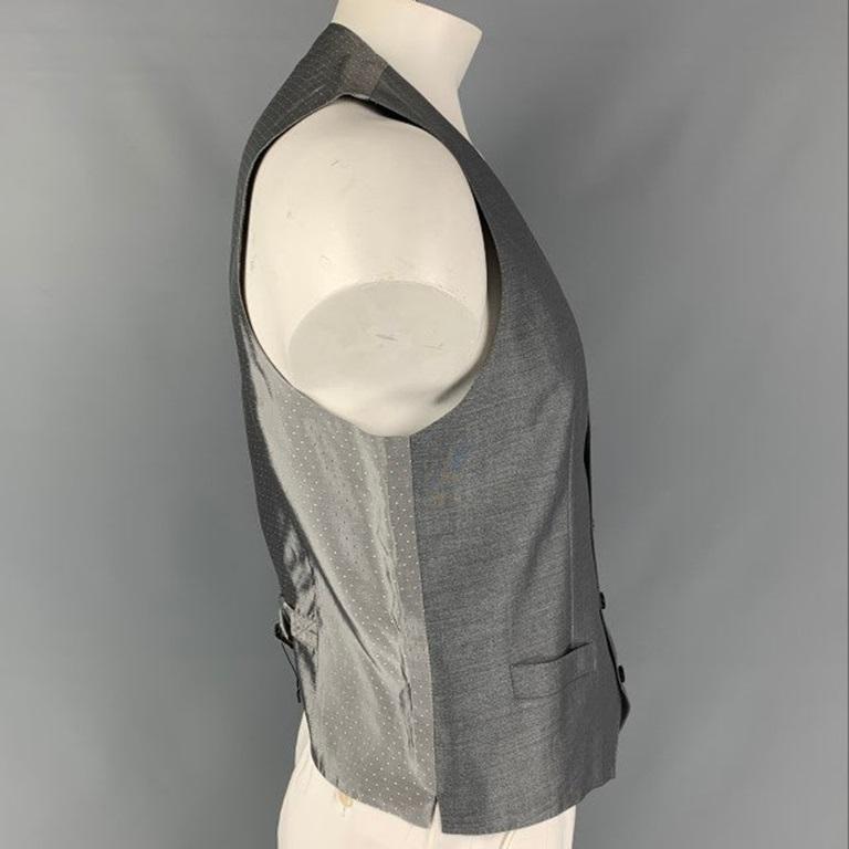 DOLCE & GABBANA basic style four buttons vest comes in a grey wool and silk featuring frontal pockets, back belts, and a buttoned closure. Made in Italy. Excellent Pre-Owned Condition. 

Marked:   60 IT 

Measurements: 
 
Shoulder: 14.5 inches