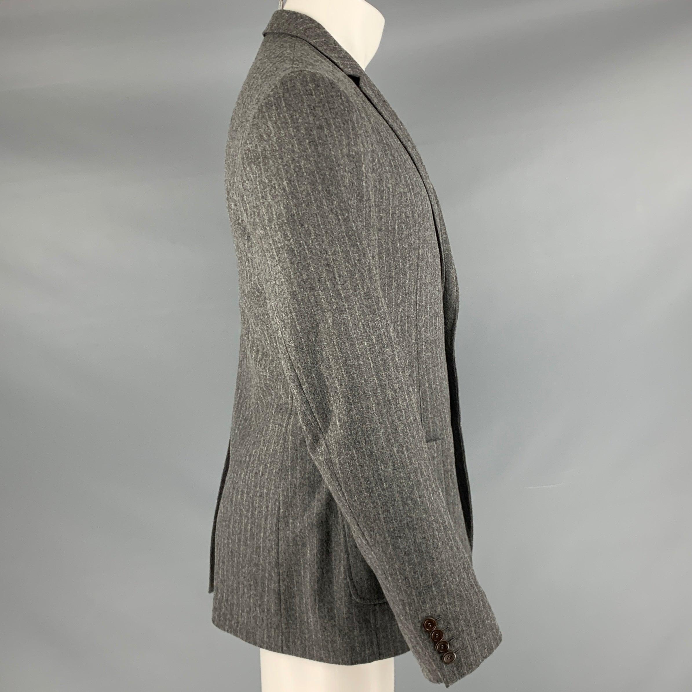 D&G by DOLCE & GABBANA sport coat
in a
grey wool blend fabric featuring a stripe pattern, notch lapel, single vented back, and double button closure.Very Good Pre-Owned Condition. Signs of wear on top button. 

Marked:   IT 50 

Measurements: 
