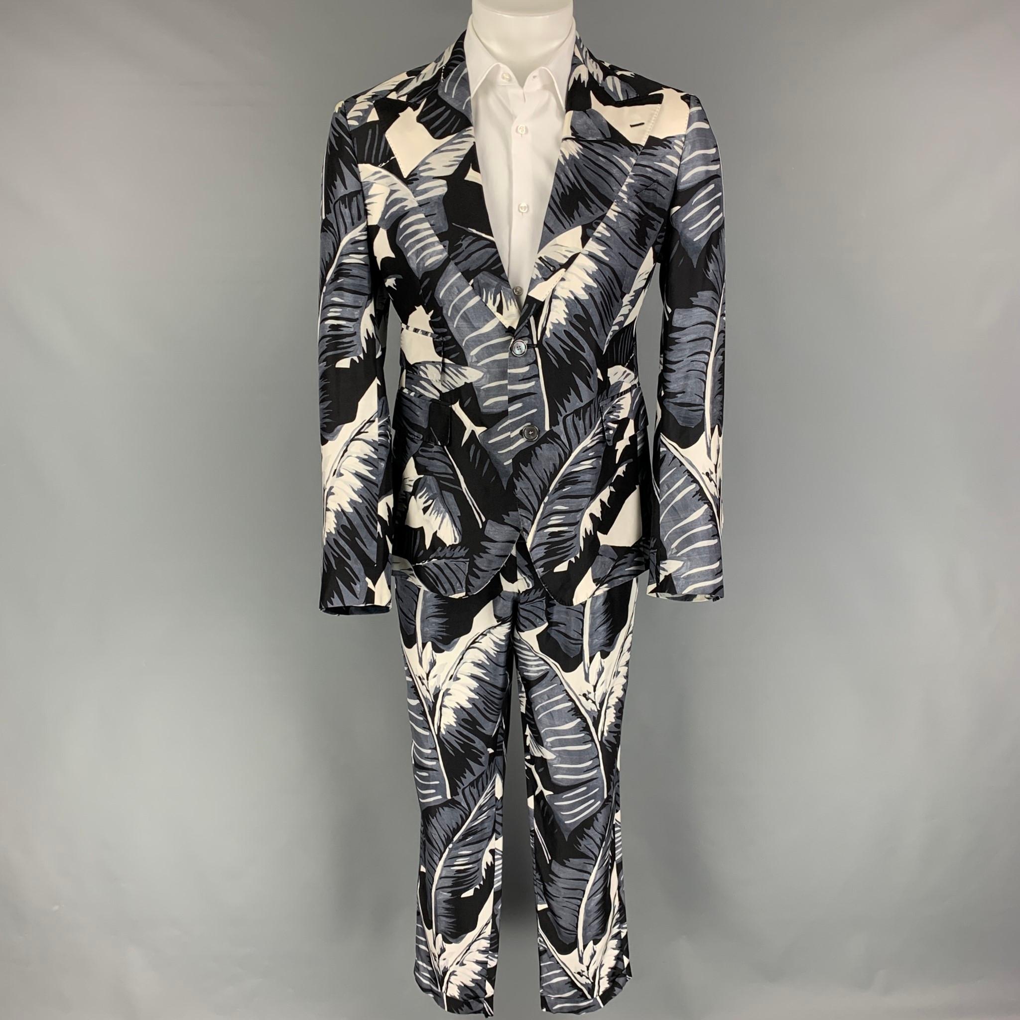 DOLCE & GABBANA suit comes in a blue & white hawaiian print silk and includes a single breasted, double button sport coat with a peak lapel and matching flat front trousers. Made in Italy.

Very Good Pre-Owned Condition.
Marked: