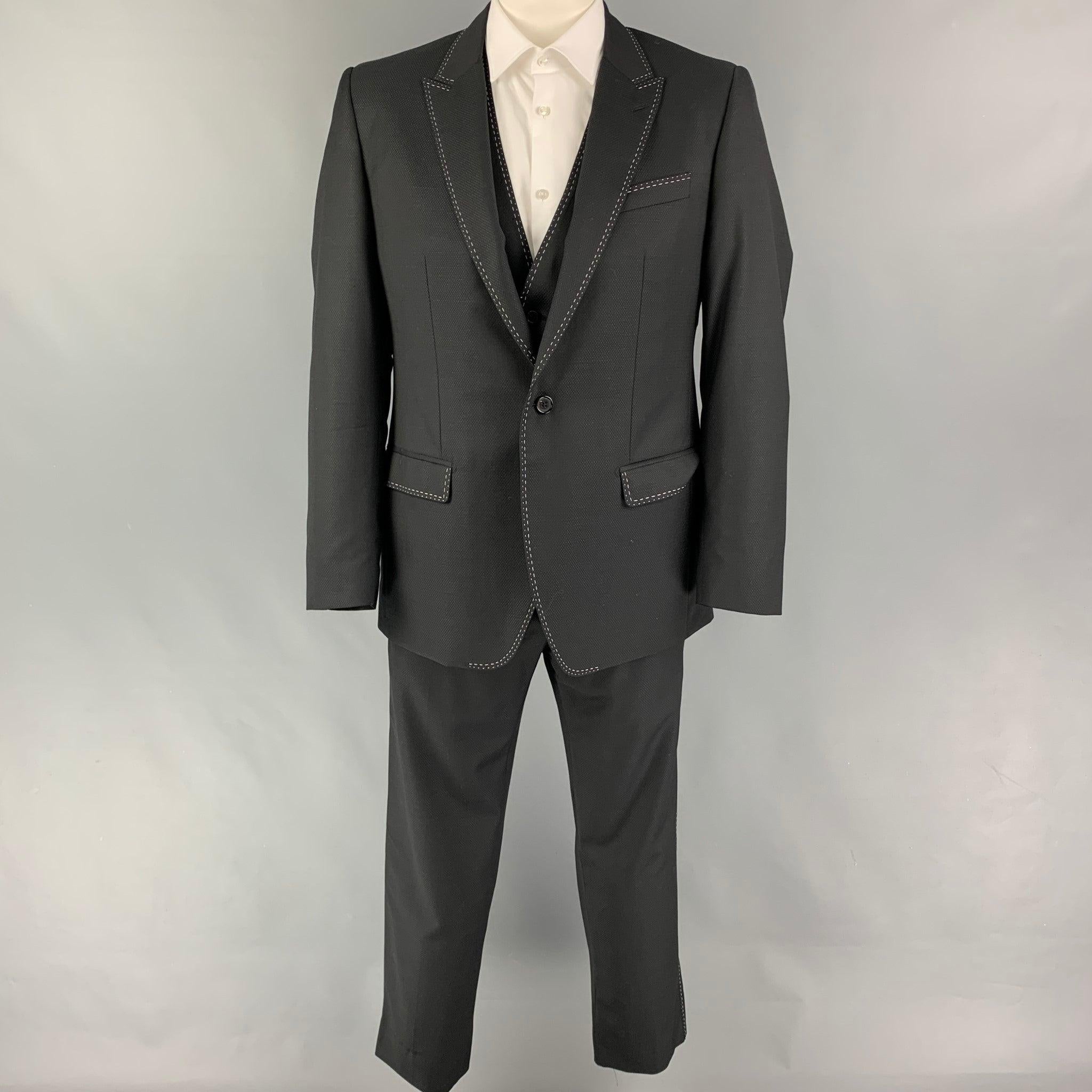 DOLCE & GABBANA 3 Piece suit comes in a black wool with a full liner and includes a single breasted, single button sport coat with a peak lapel and a matching vest & flat front trousers. Made in Italy. Excellent Pre-Owned Condition. 

Marked:   52