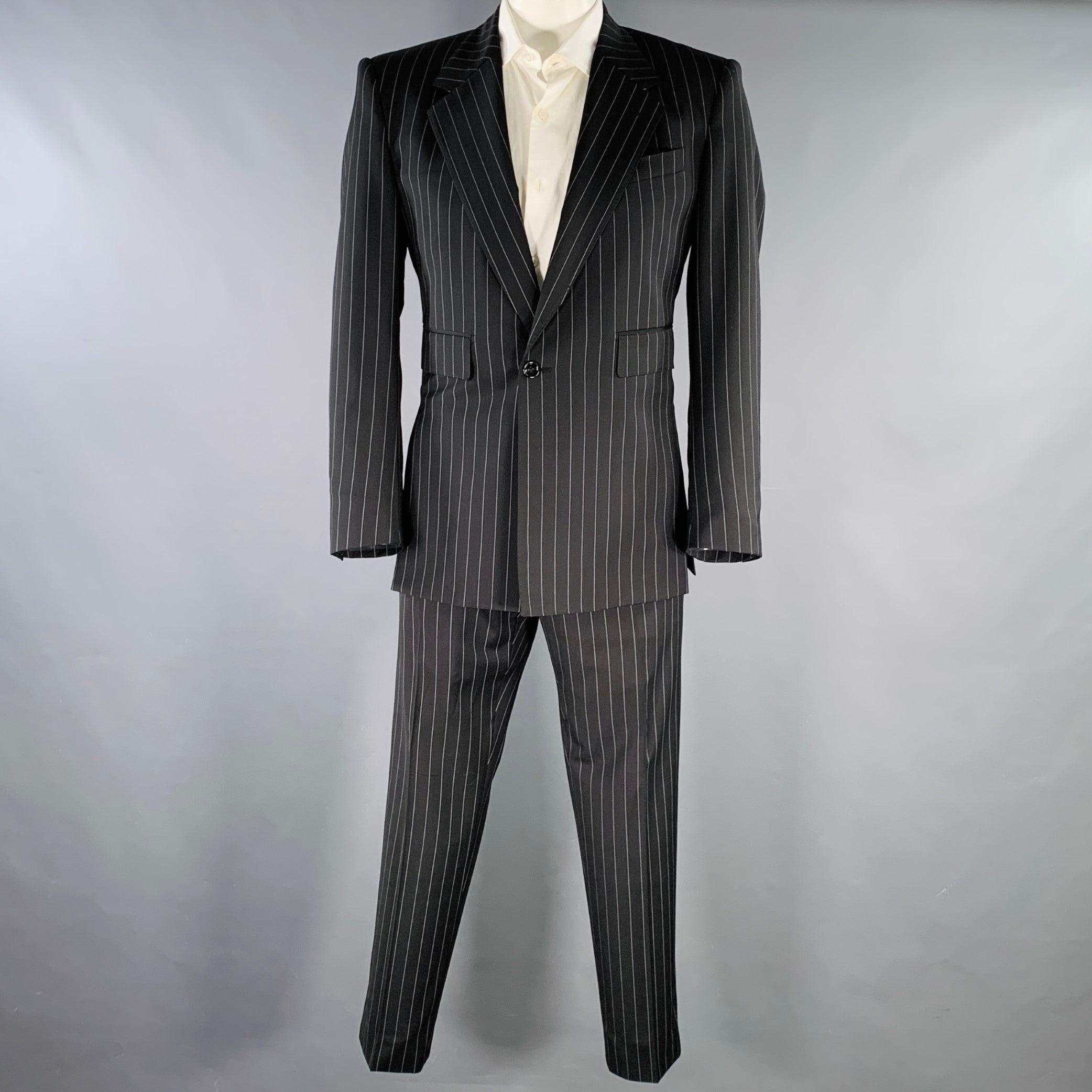 DOLCE & GABBANA
en polyester mélangé à rayures noires et grises, avec doublure complète, comprenant un manteau de sport à un seul boutonnage, avec revers à cran, et un pantalon assorti à devant plat. Fabriqué en Italie. Excellent état. 

Marqué :  