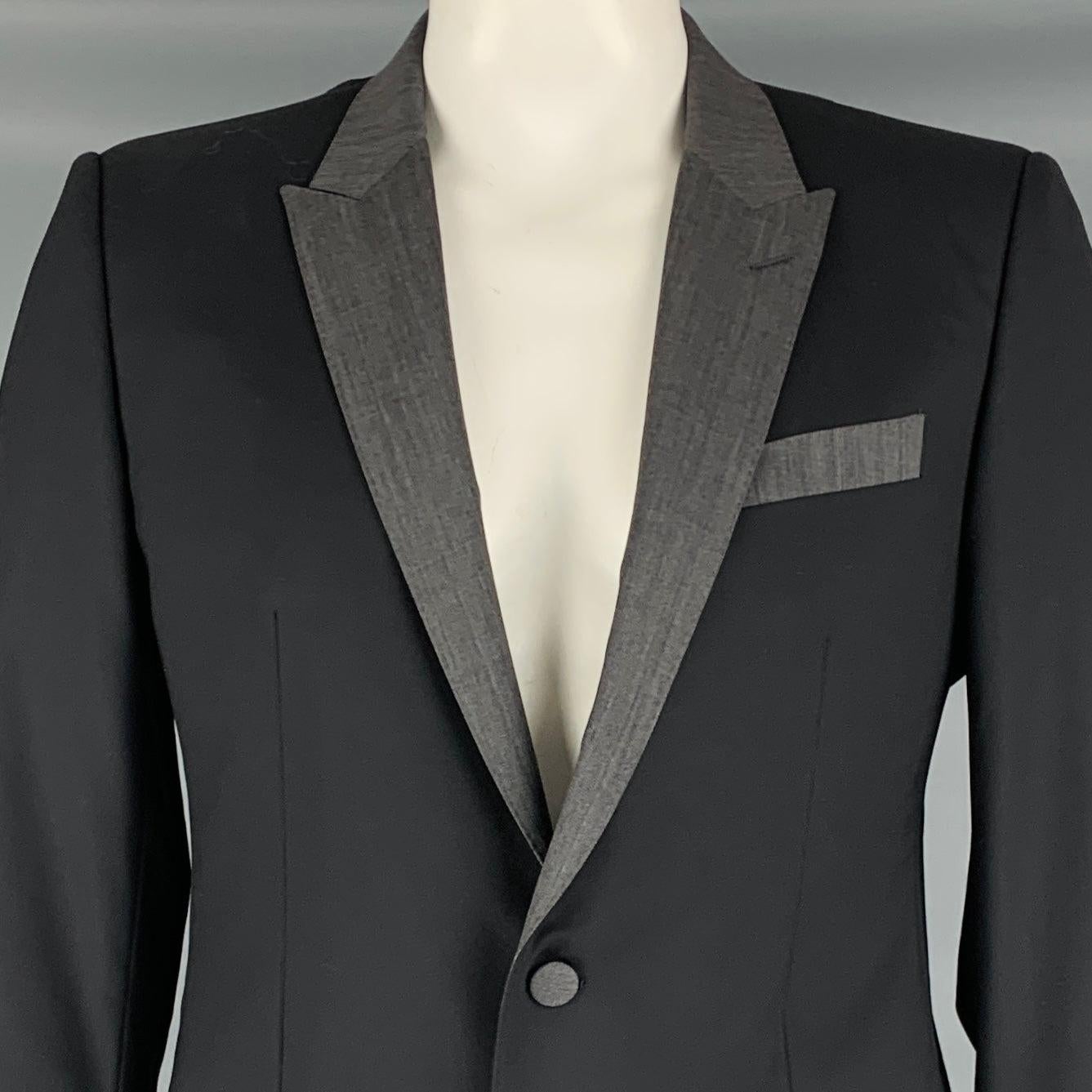 DOLCE & GABBANA sport coat
in a black and grey wool blend fabric featuring peak lapel, single vented back, and double button closure. Made in Italy.Very Good Pre-Owned Condition. Marks under arms. 

Marked:   IT 52 

Measurements: 
 
Shoulder: 17