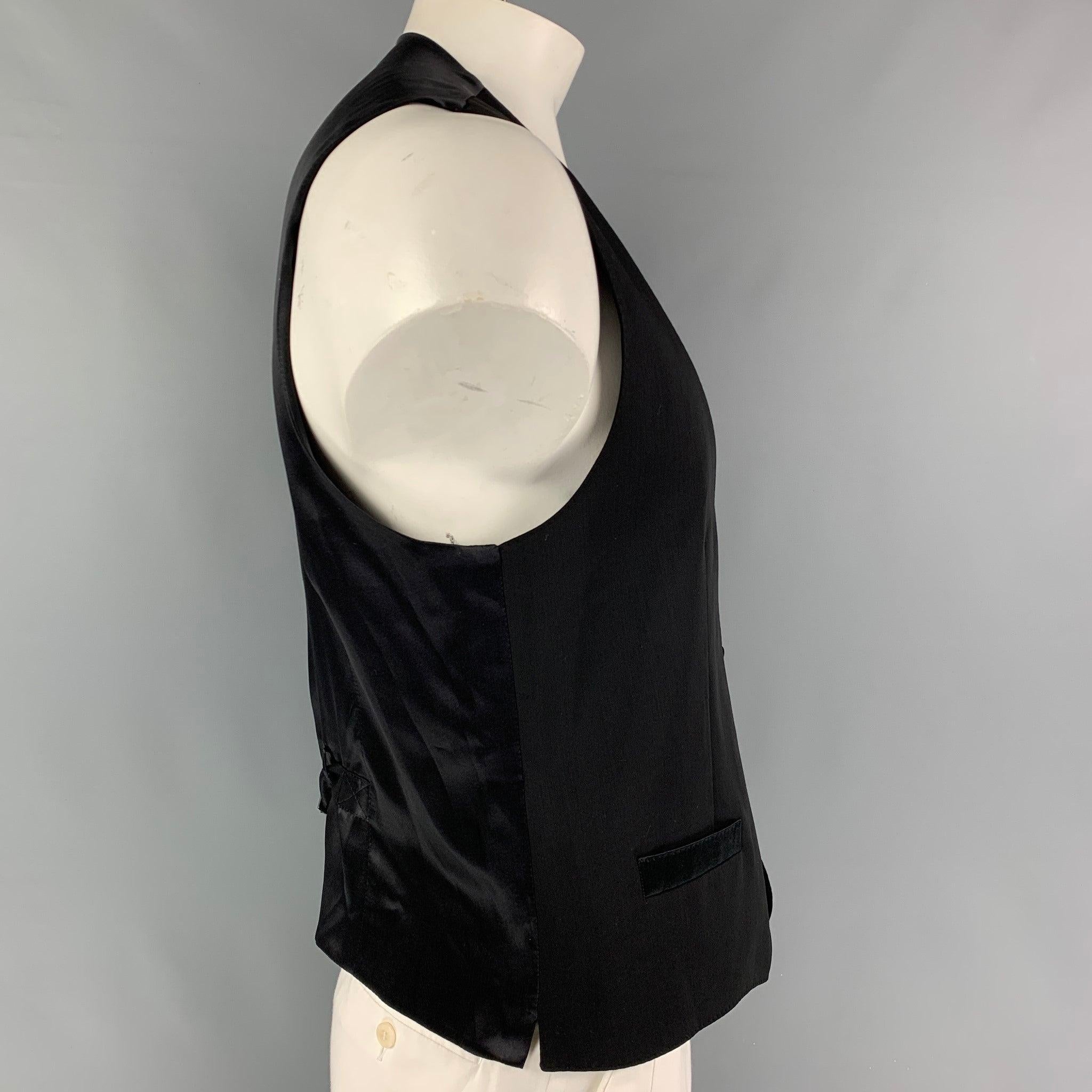 DOLCE & GABBANA vest comes in a black wool / silk featuring slit pockets, back belt, and a buttoned closure. Made in Italy. Very Good
Pre-Owned Condition. 

Marked:   52 

Measurements: 
 
Shoulder: 15 inches  Chest: 42 inches  Length: 23.5 inches 
