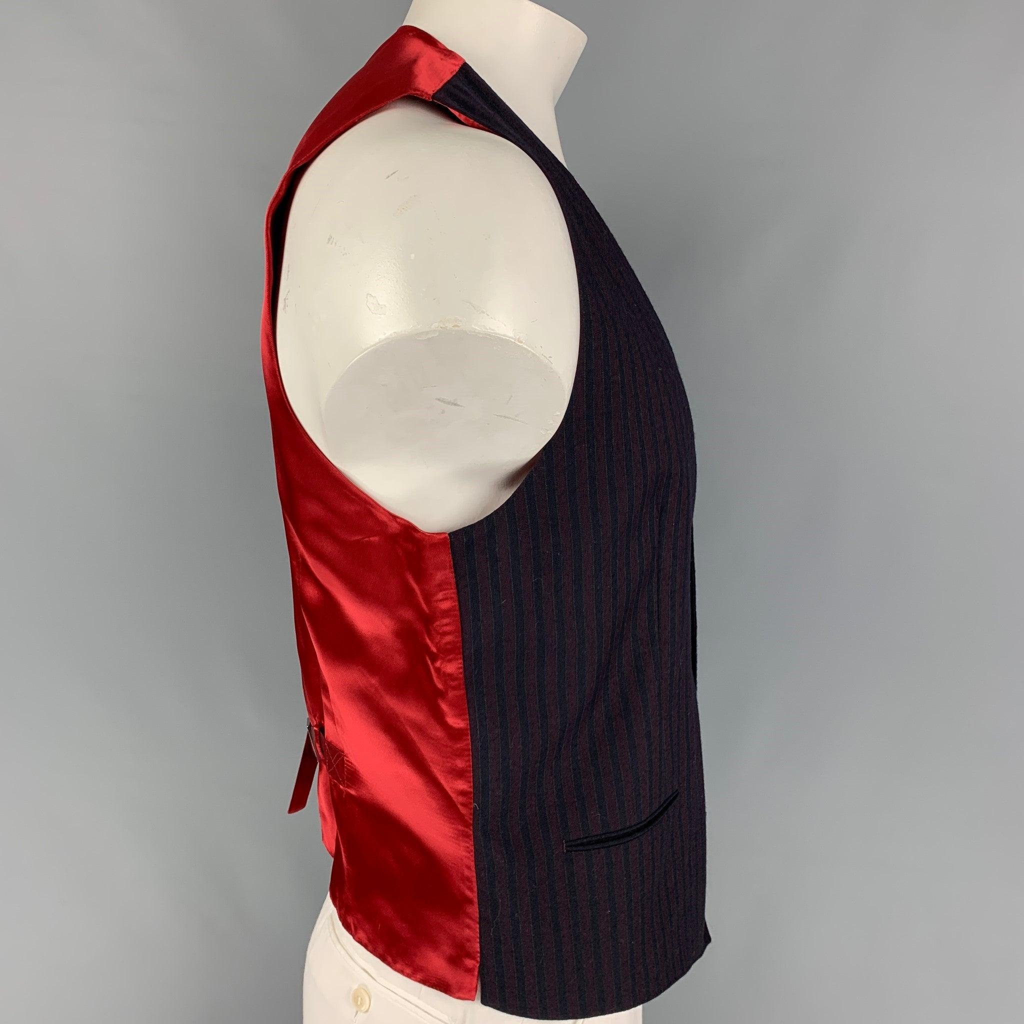 DOLCE & GABBANA vest comes in a navy & burgundy vertical stripe material with a red back panel featuring a back belt, slit pockets, and a buttoned closure. Made in Italy.
Very Good
Pre-Owned Condition. Fabric tag removed.  

Marked:   Size tag