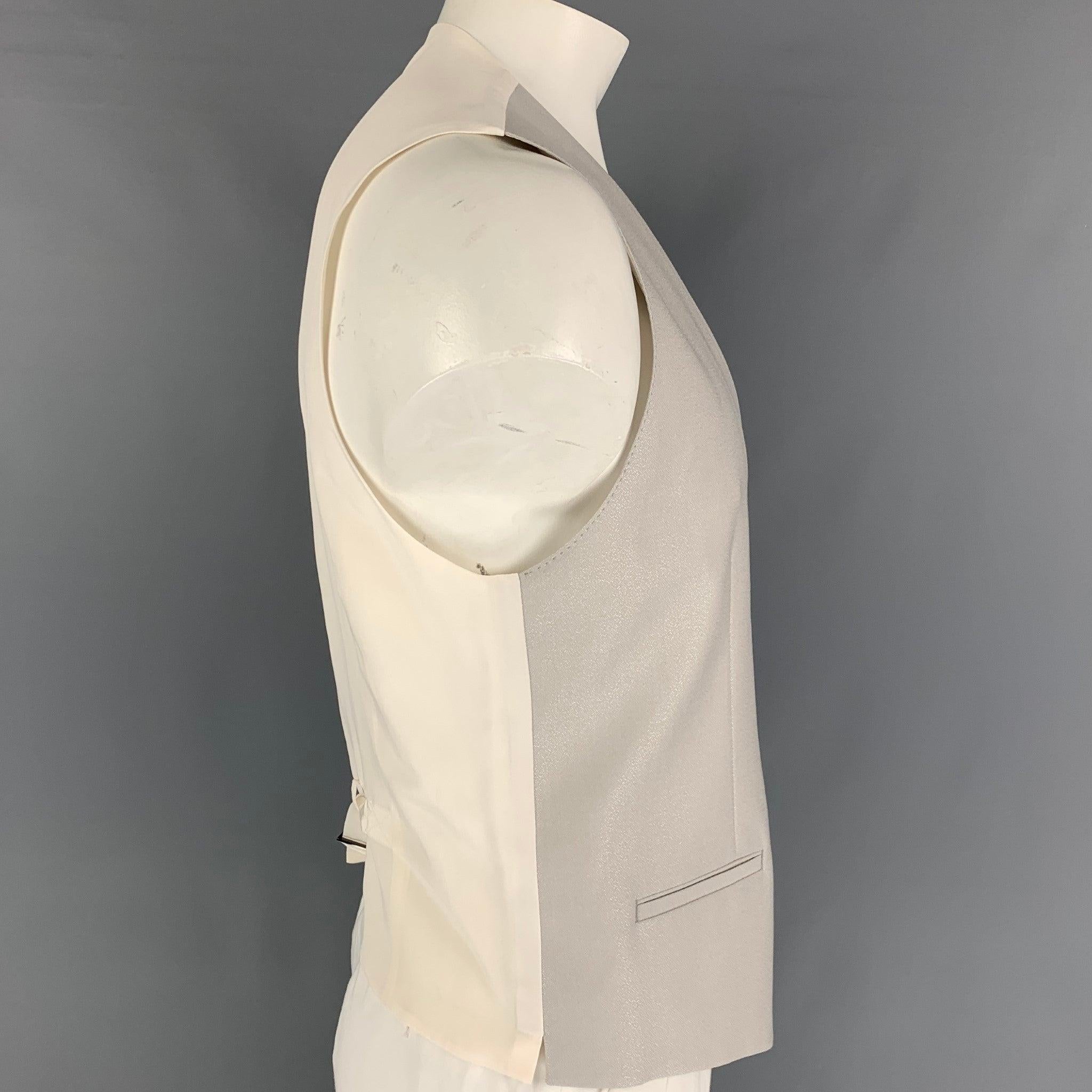 DOLCE & GABBANA
dress vest comes in a silver & beige wool / silk featuring a back belt, front pockets, and a buttoned closure.
Very Good
Pre-Owned Condition. 

Marked:   52 

Measurements: 
 
Shoulder: 15 inches  Chest: 42 inches  Length: 24 inches